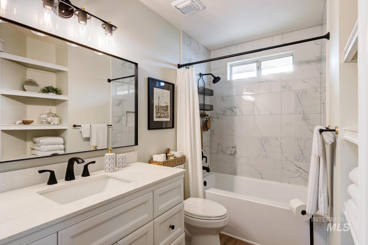Full bath featuring shower / tub combo and vanity