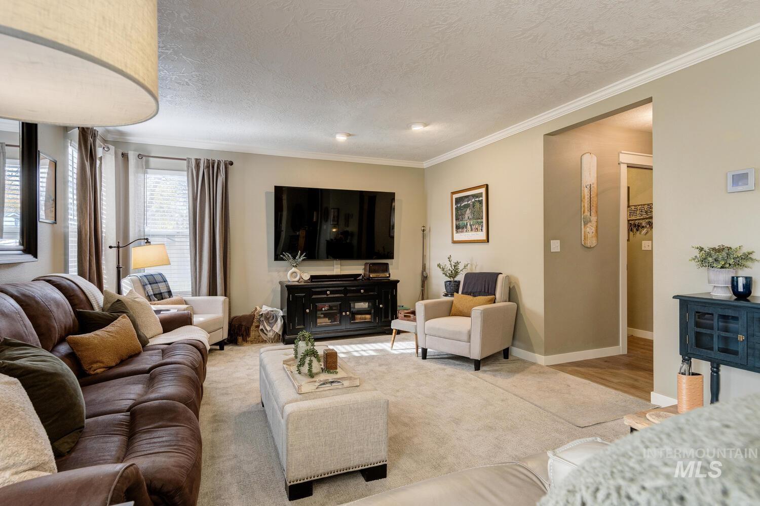 Living area with crown molding, a textured ceiling