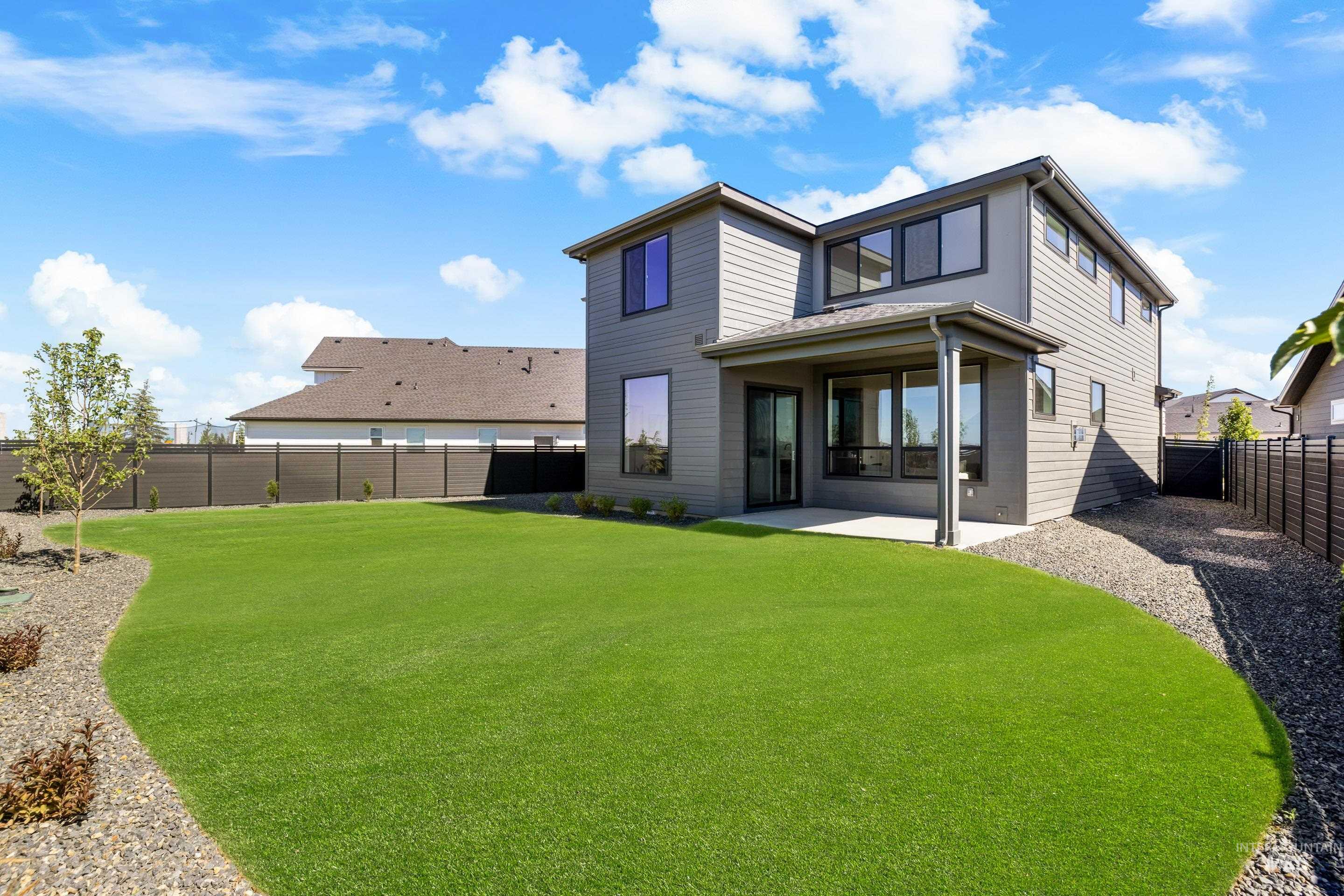 Rear view of property with a fenced backyard and a patio