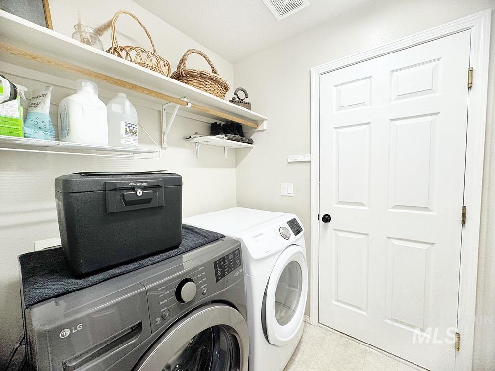 Laundry room with washing machine and dryer and light tile patterned flooring