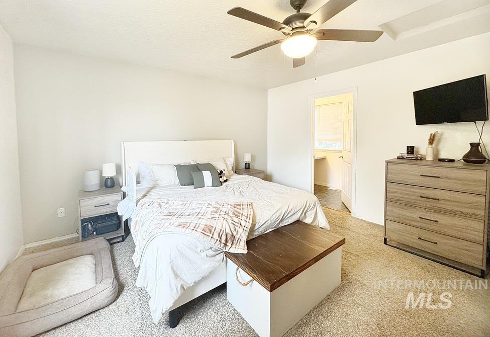 Bedroom with ceiling fan and light carpet