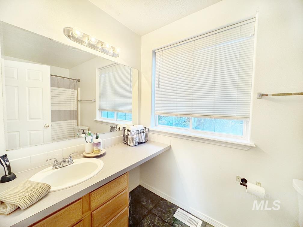 Full bath with vanity, a shower with shower curtain, and a textured ceiling