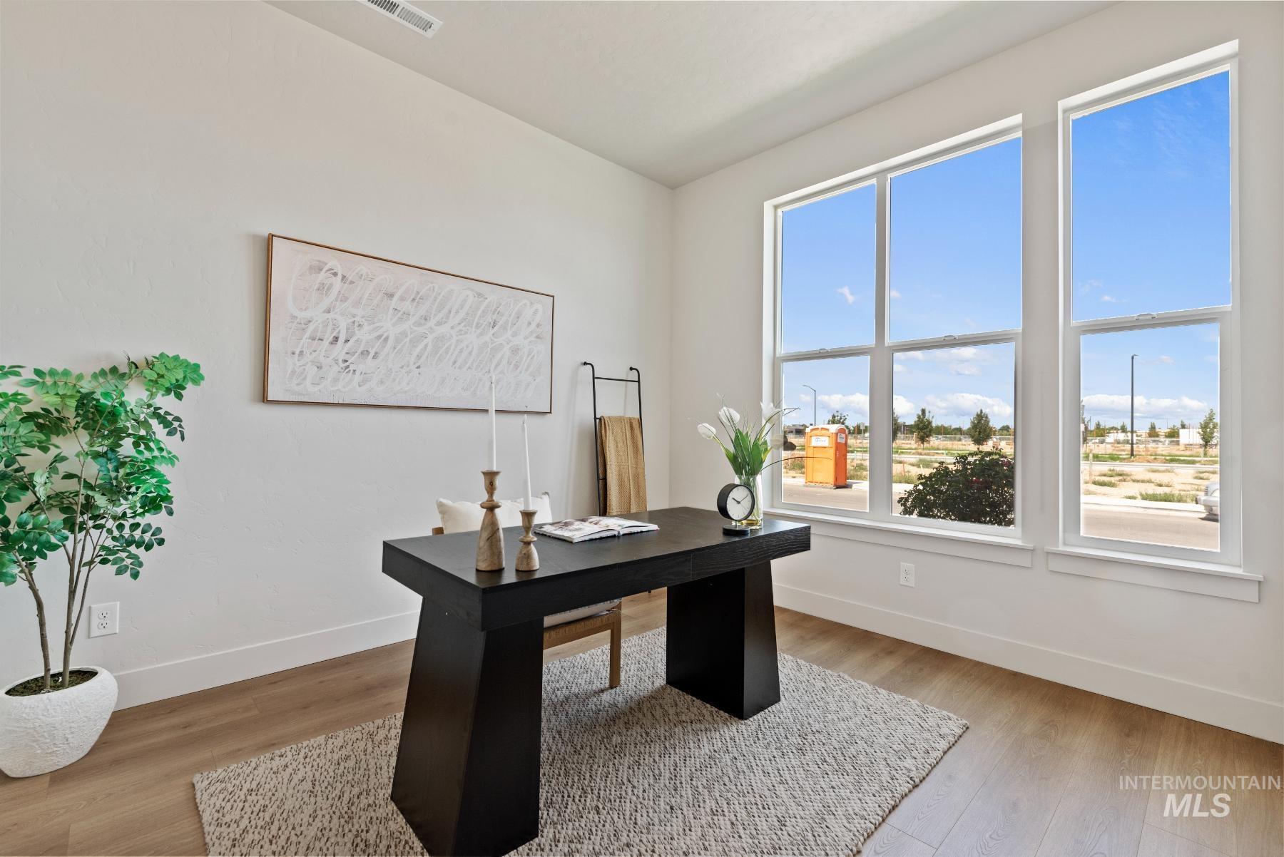 Office area with baseboards and light wood-style flooring