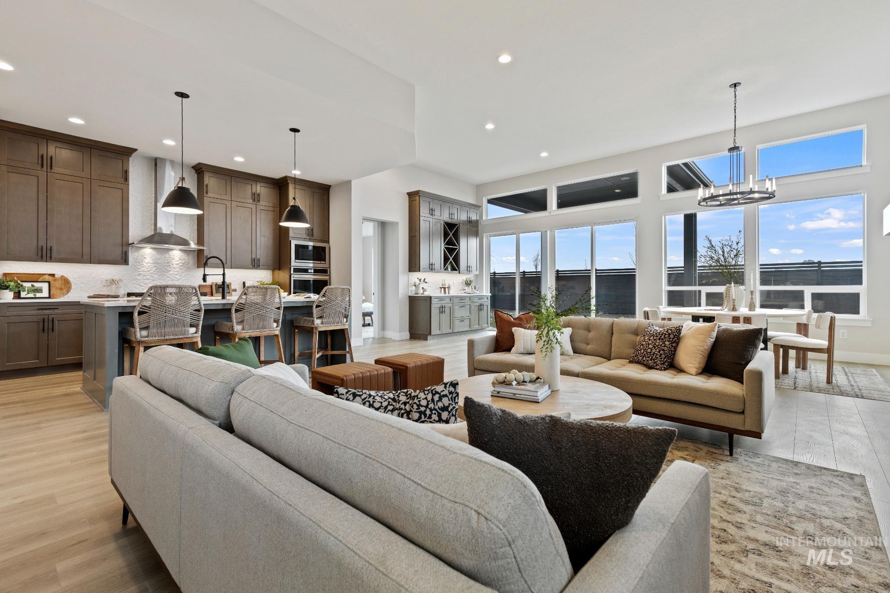 Living room with light wood finished floors, recessed lighting, and a chandelier