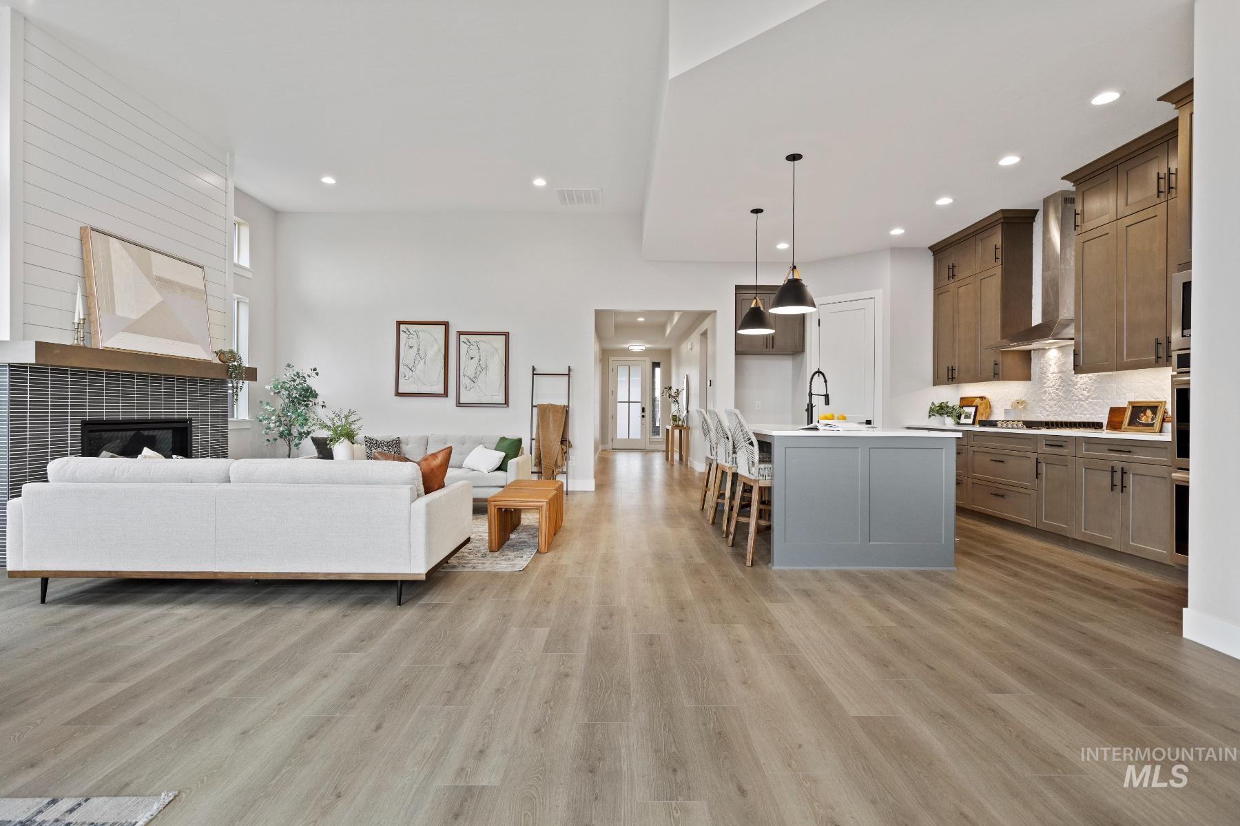 Living area with a fireplace, light wood-style floors, and recessed lighting