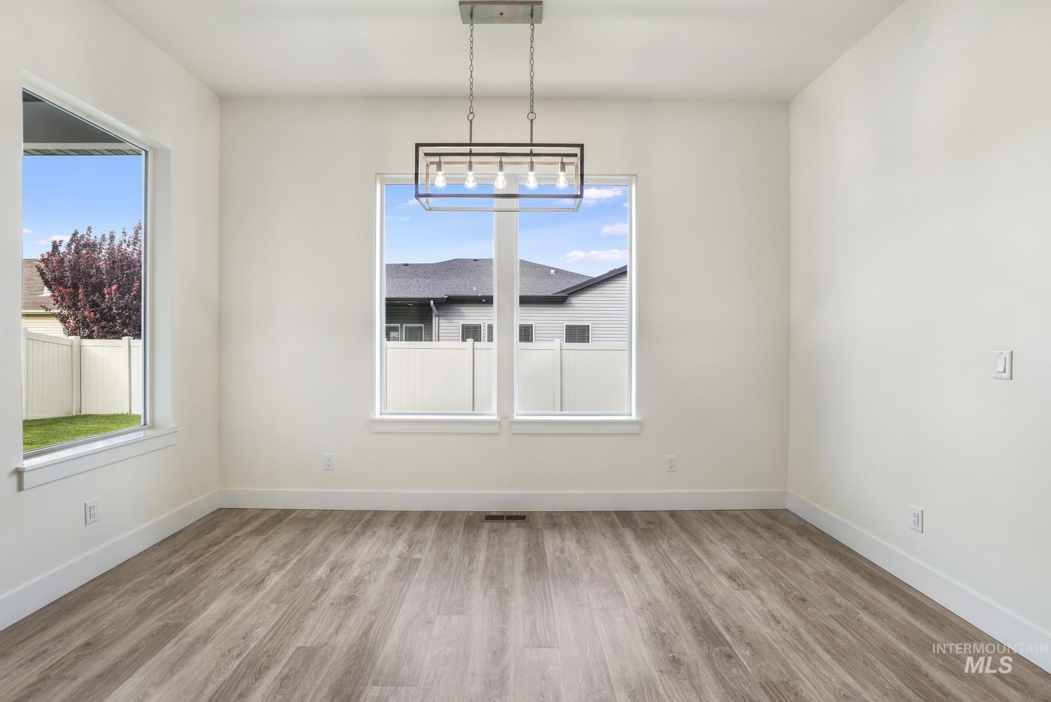 Unfurnished dining area with light wood-style flooring and a chandelier