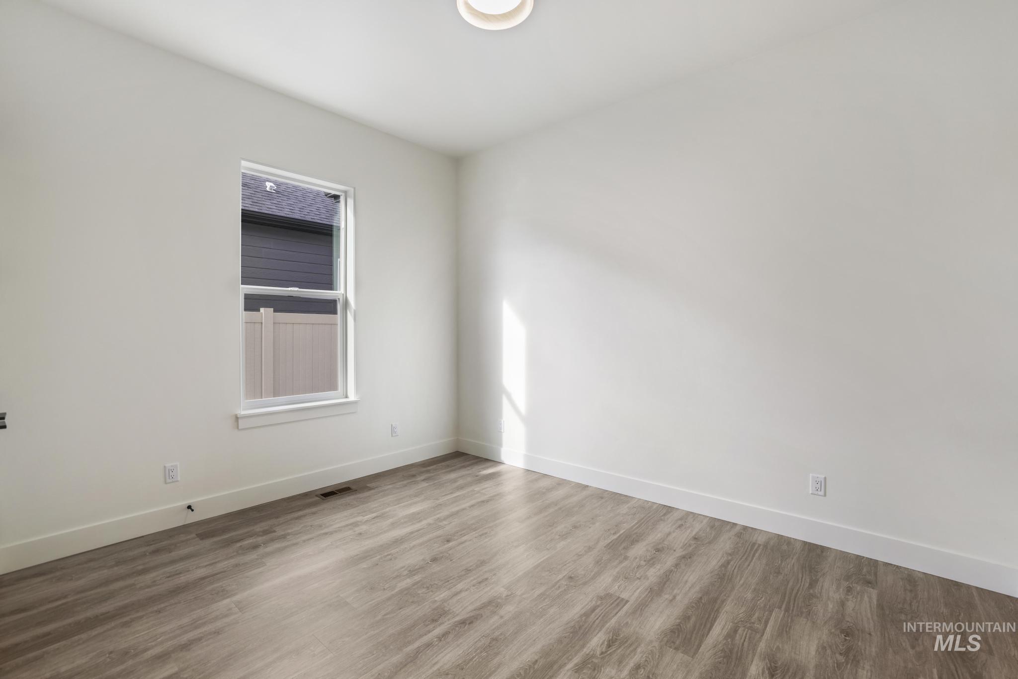 Unfurnished room featuring wood finished floors and baseboards