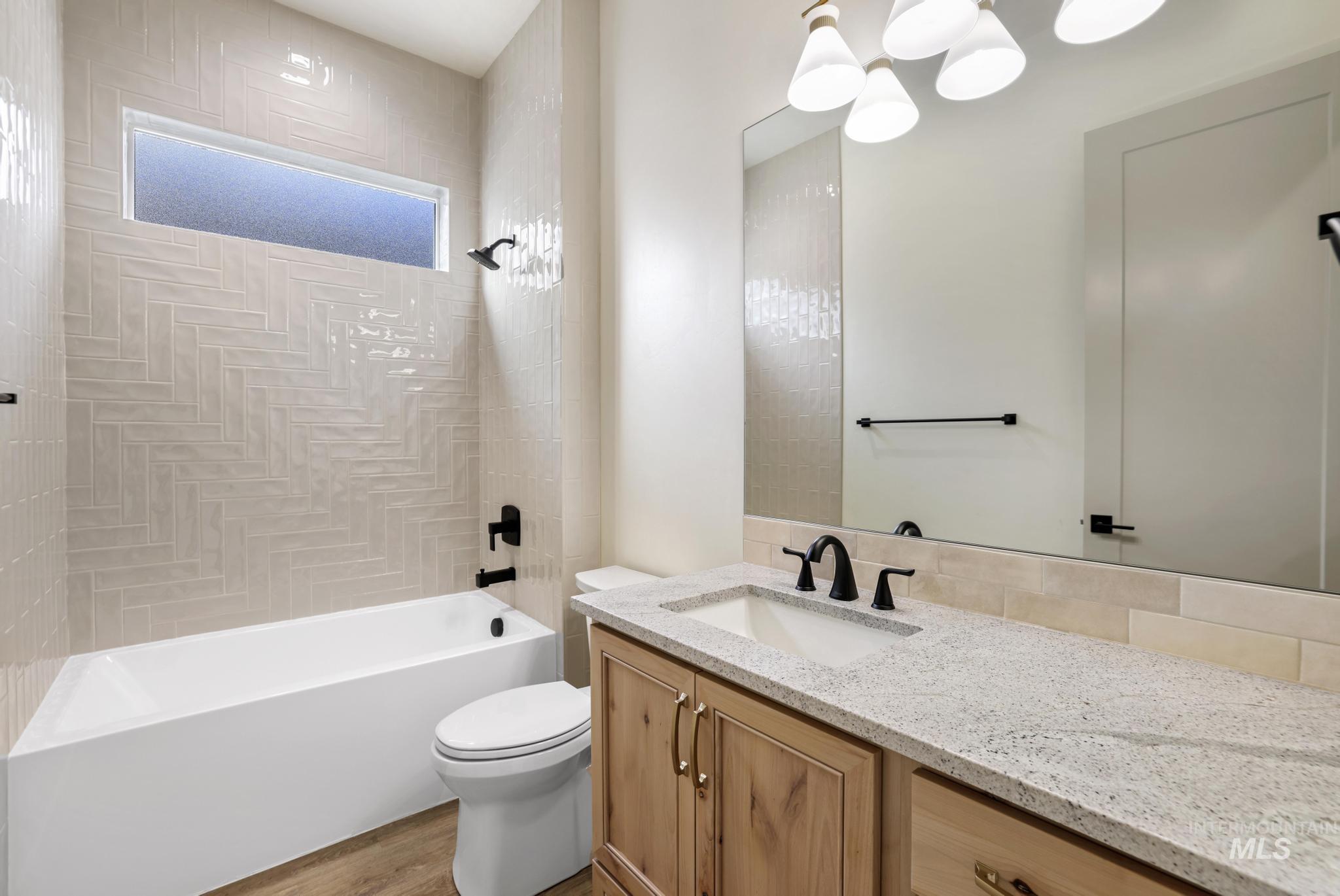 Full bathroom featuring bathtub / shower combination, vanity, and light wood finished floors