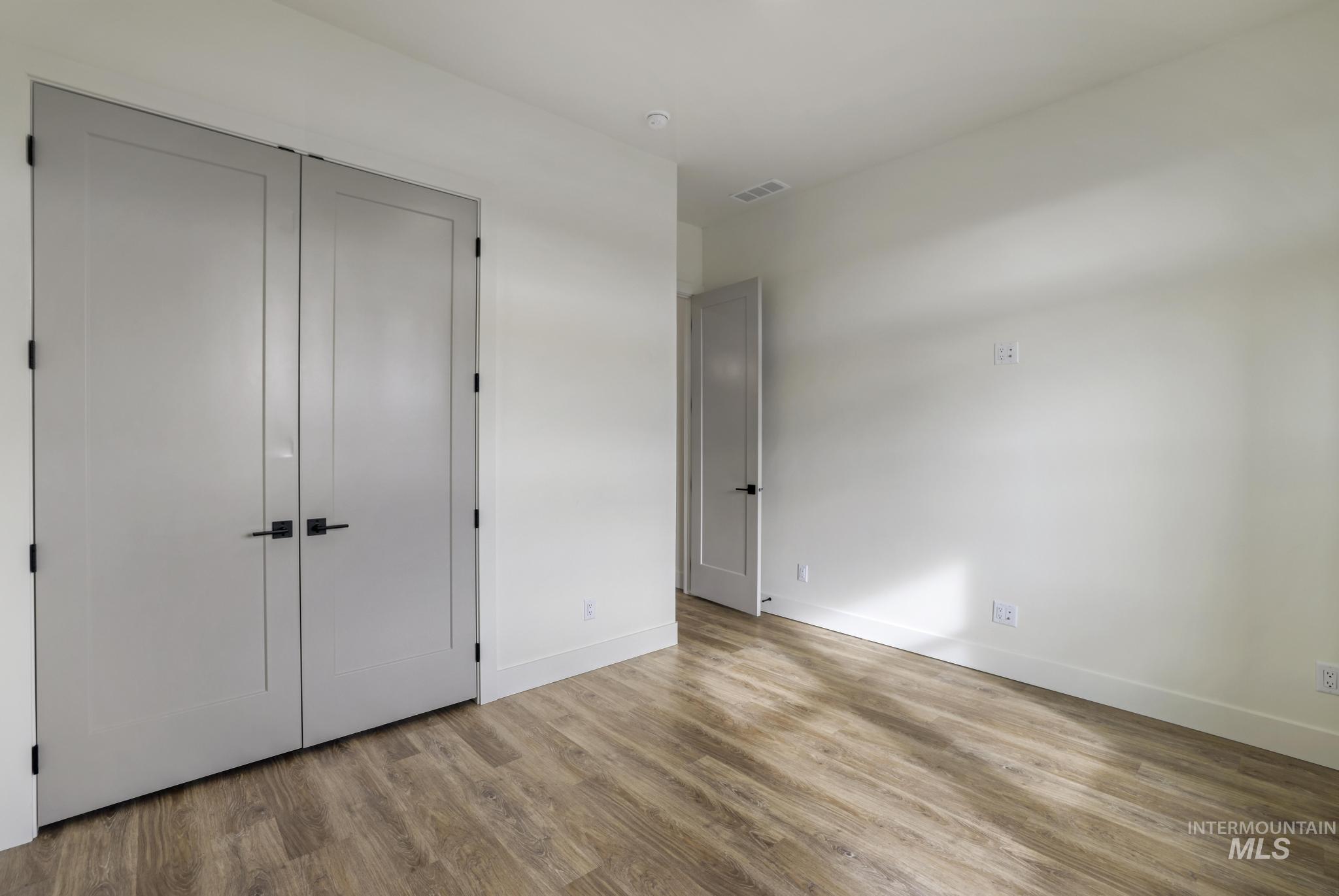 Unfurnished bedroom with light wood-style floors and a closet