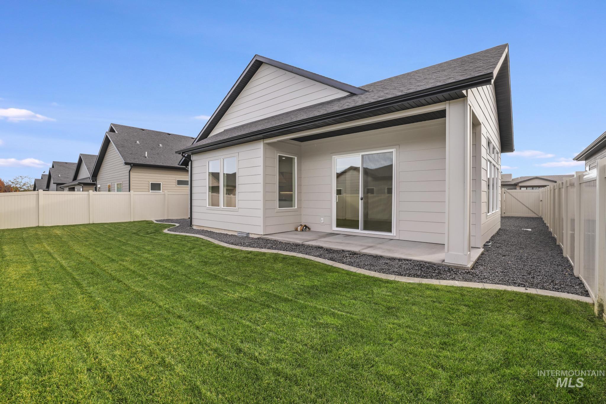 Back of house with a fenced backyard and a patio area