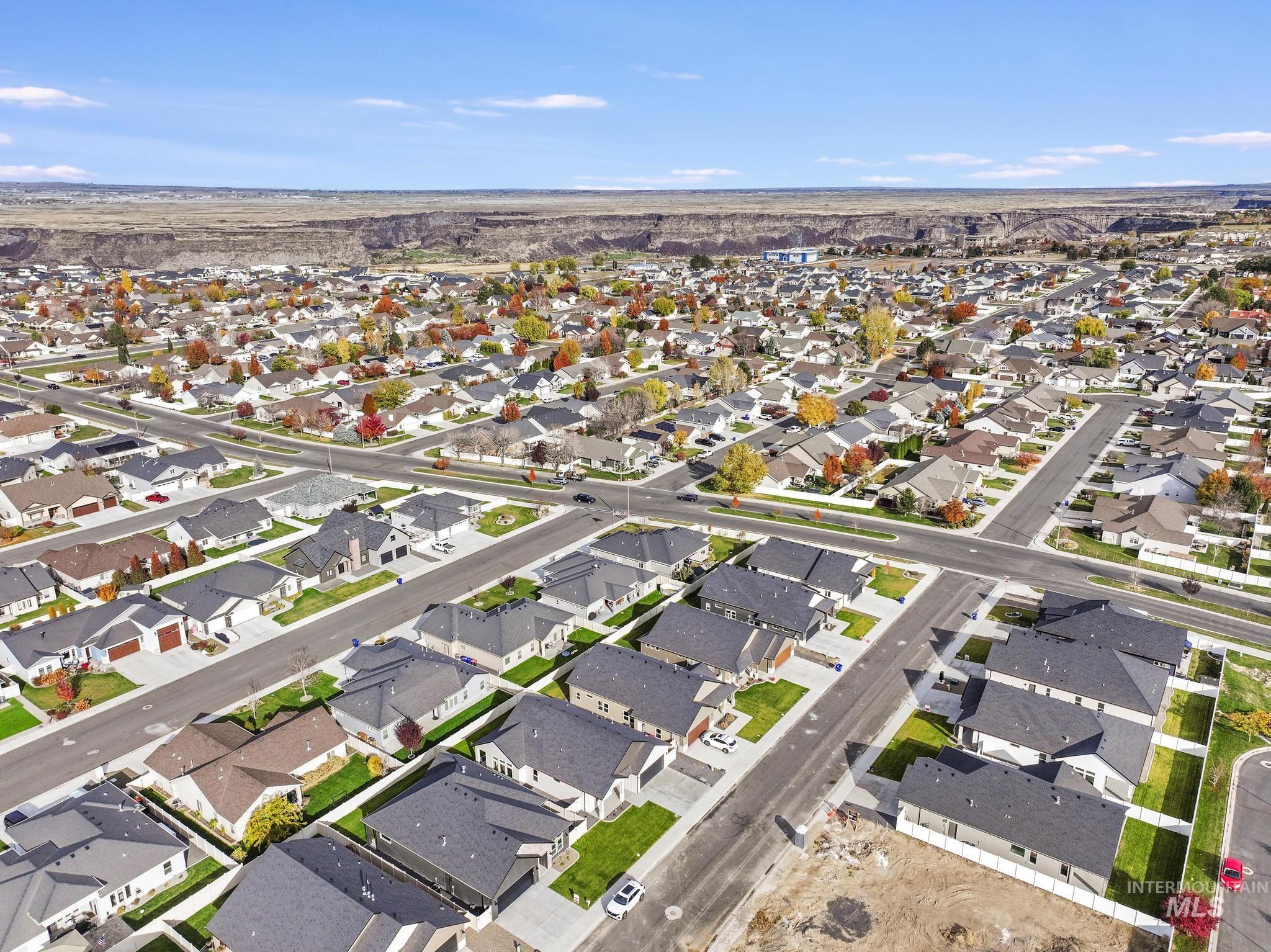 Aerial view of property and surrounding area featuring nearby suburban area