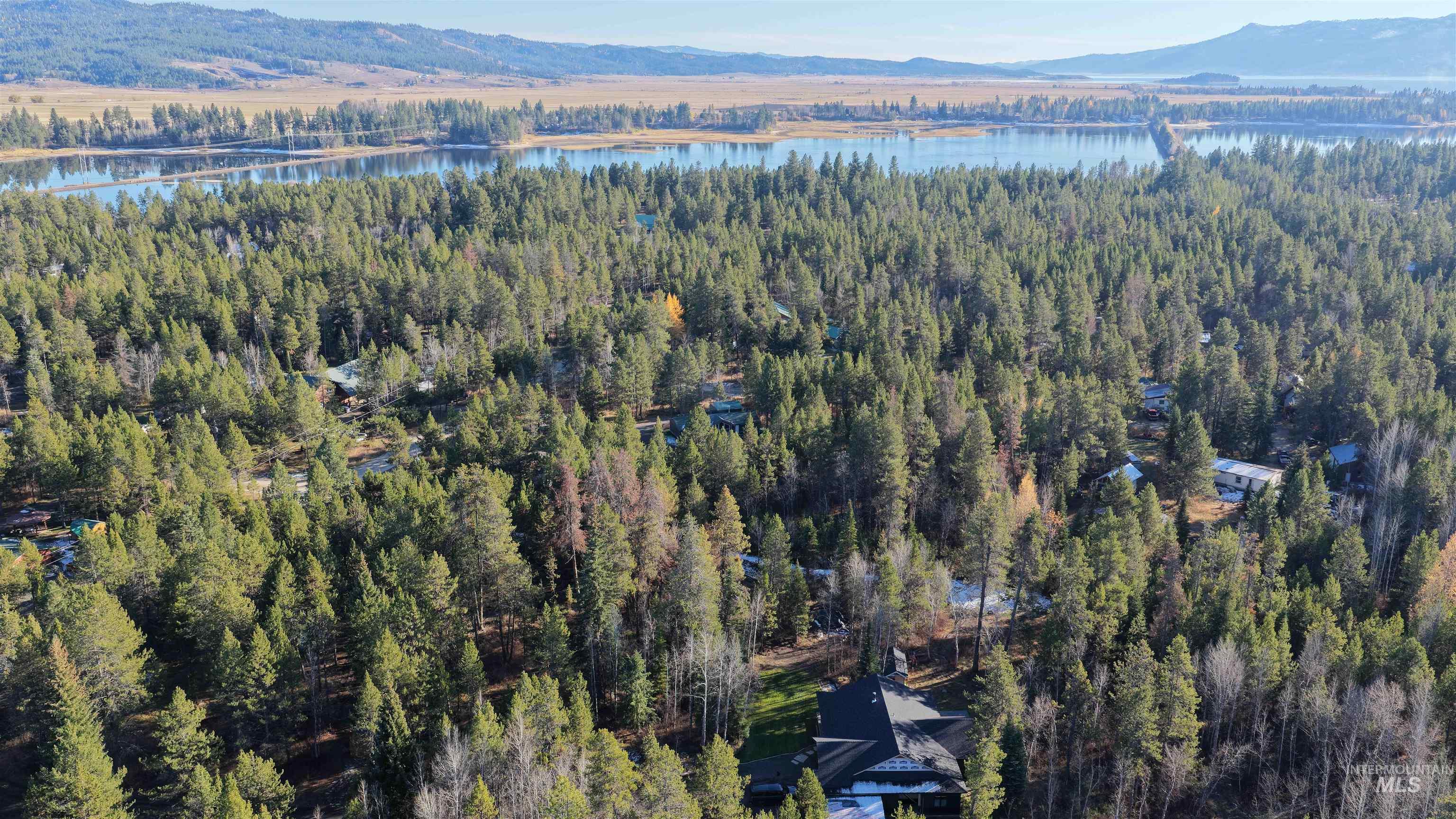 Aerial view of property's location with a water and mountain view and a forest