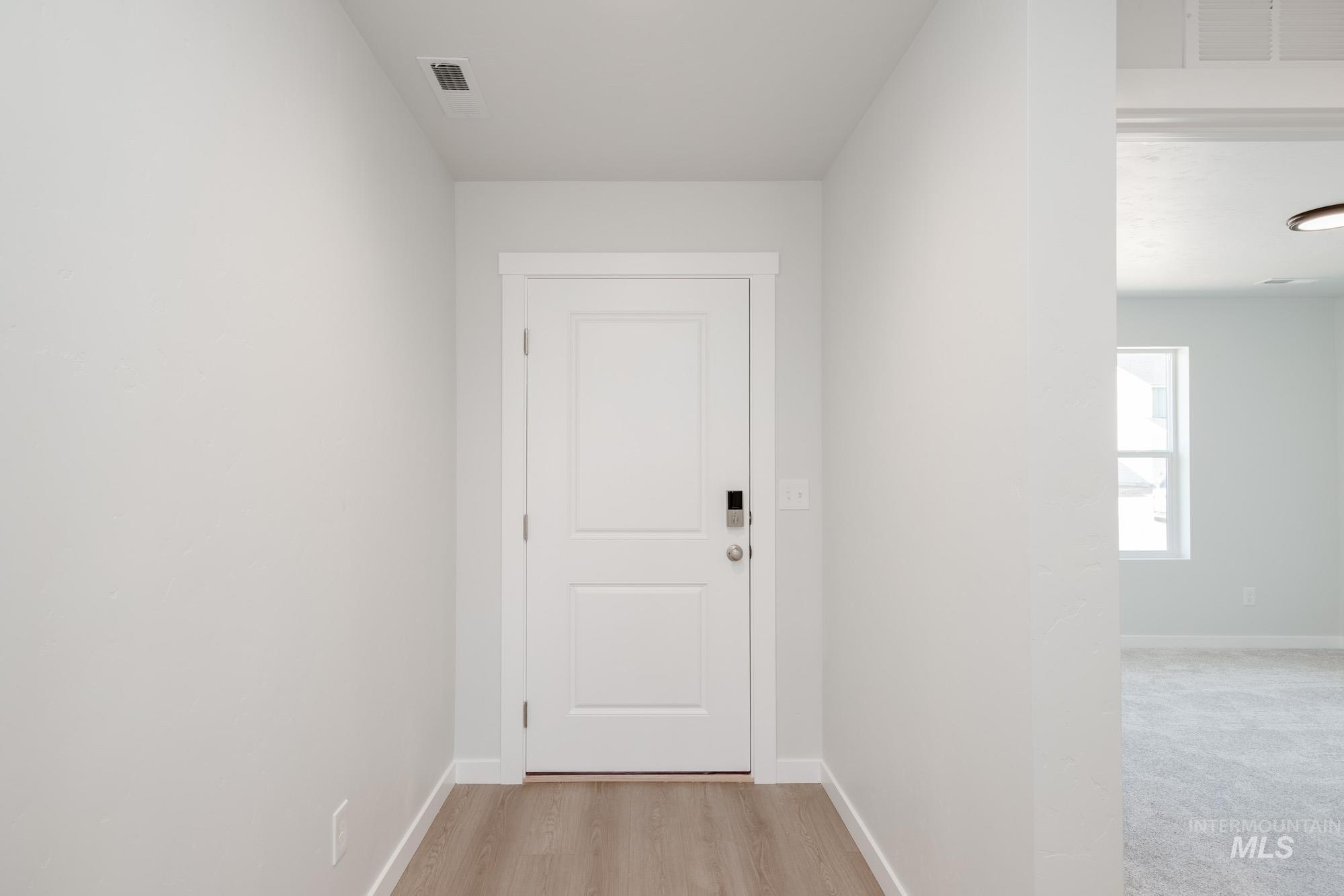 Doorway with baseboards and wood finished floors