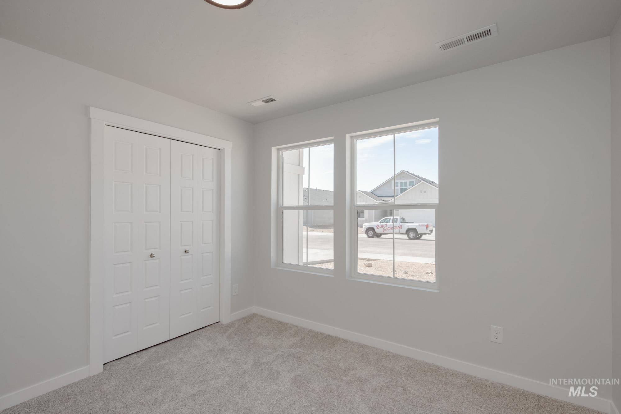 Unfurnished bedroom featuring light colored carpet and a closet