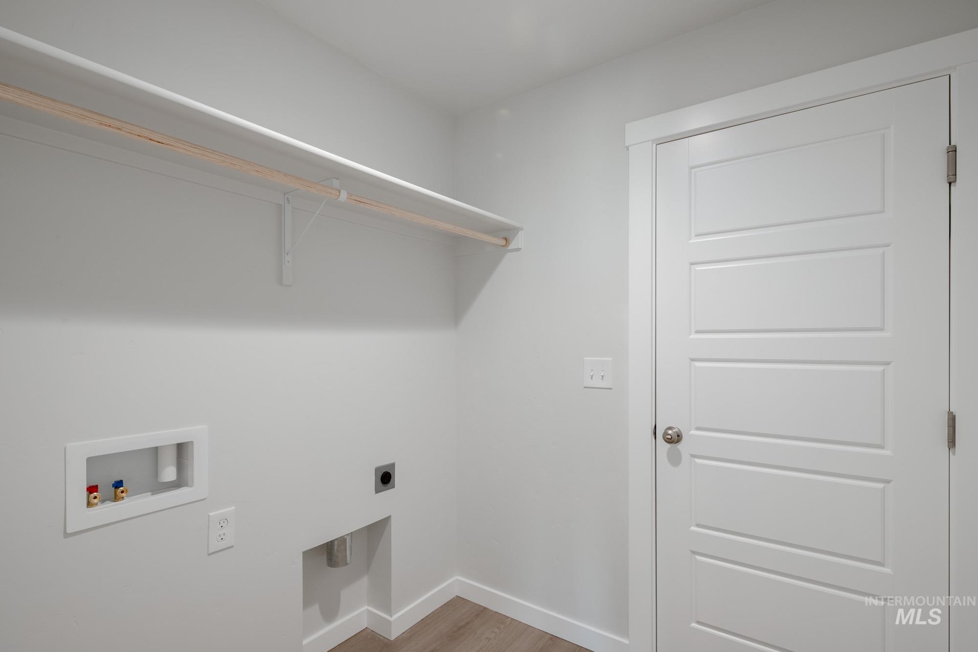 Laundry room with washer hookup, electric dryer hookup, and light wood-style floors