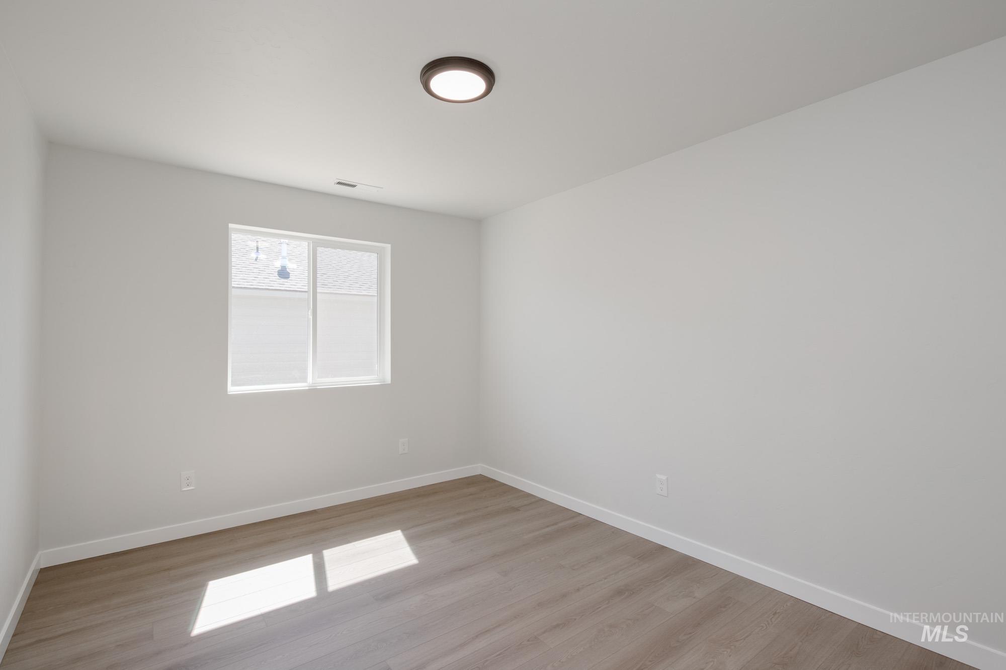 Spare room featuring baseboards and light wood-type flooring