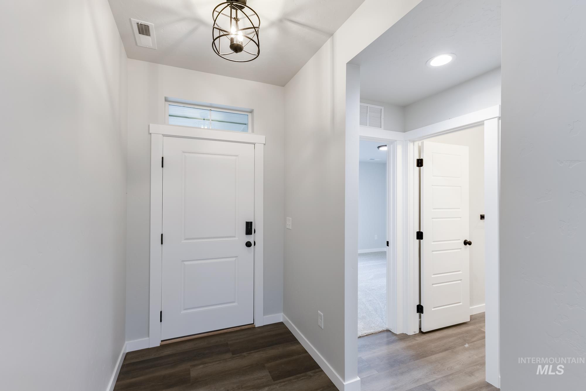 Entryway with dark wood-style flooring, a chandelier, and recessed lighting