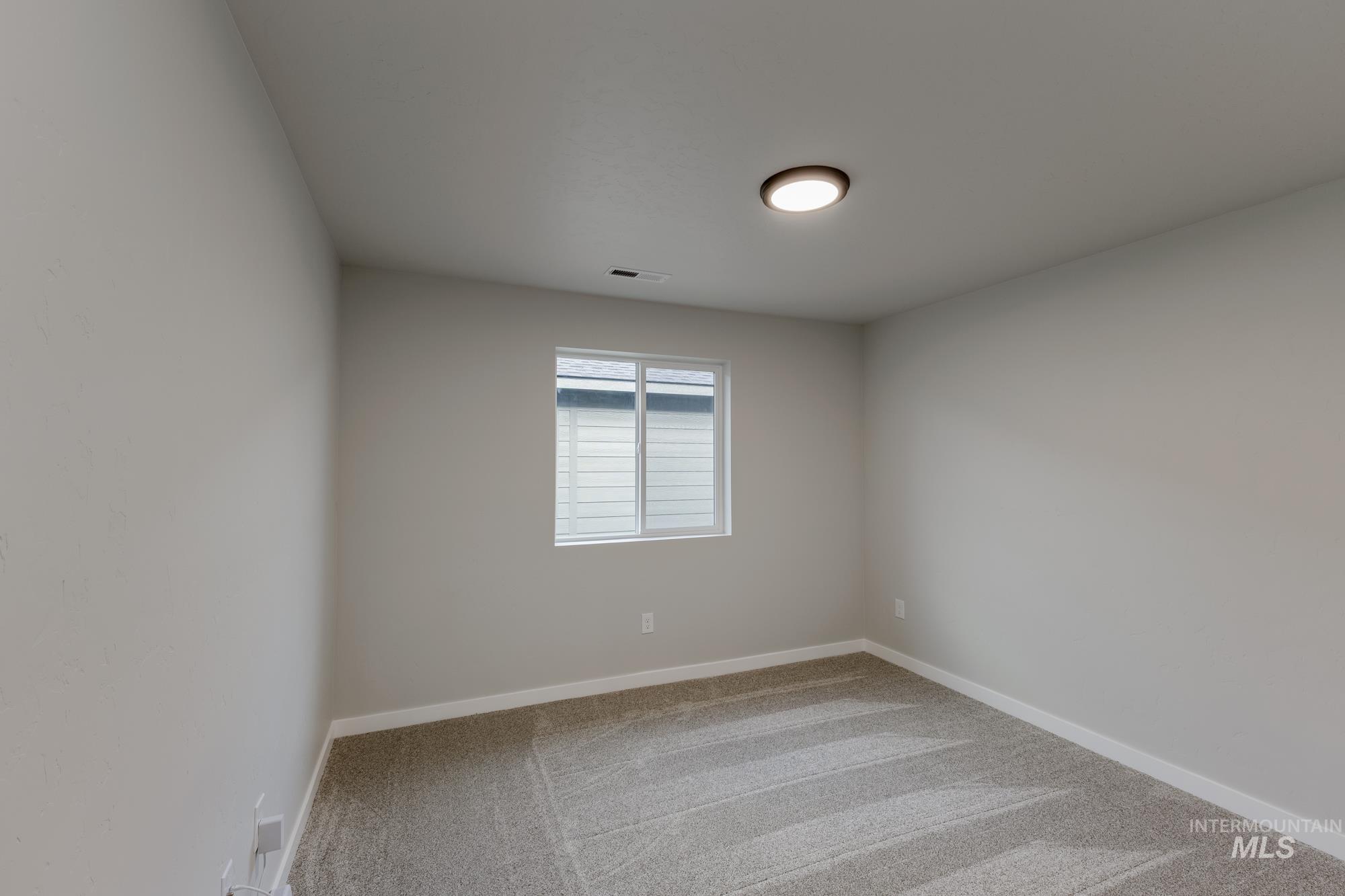 Spare room with light carpet and baseboards