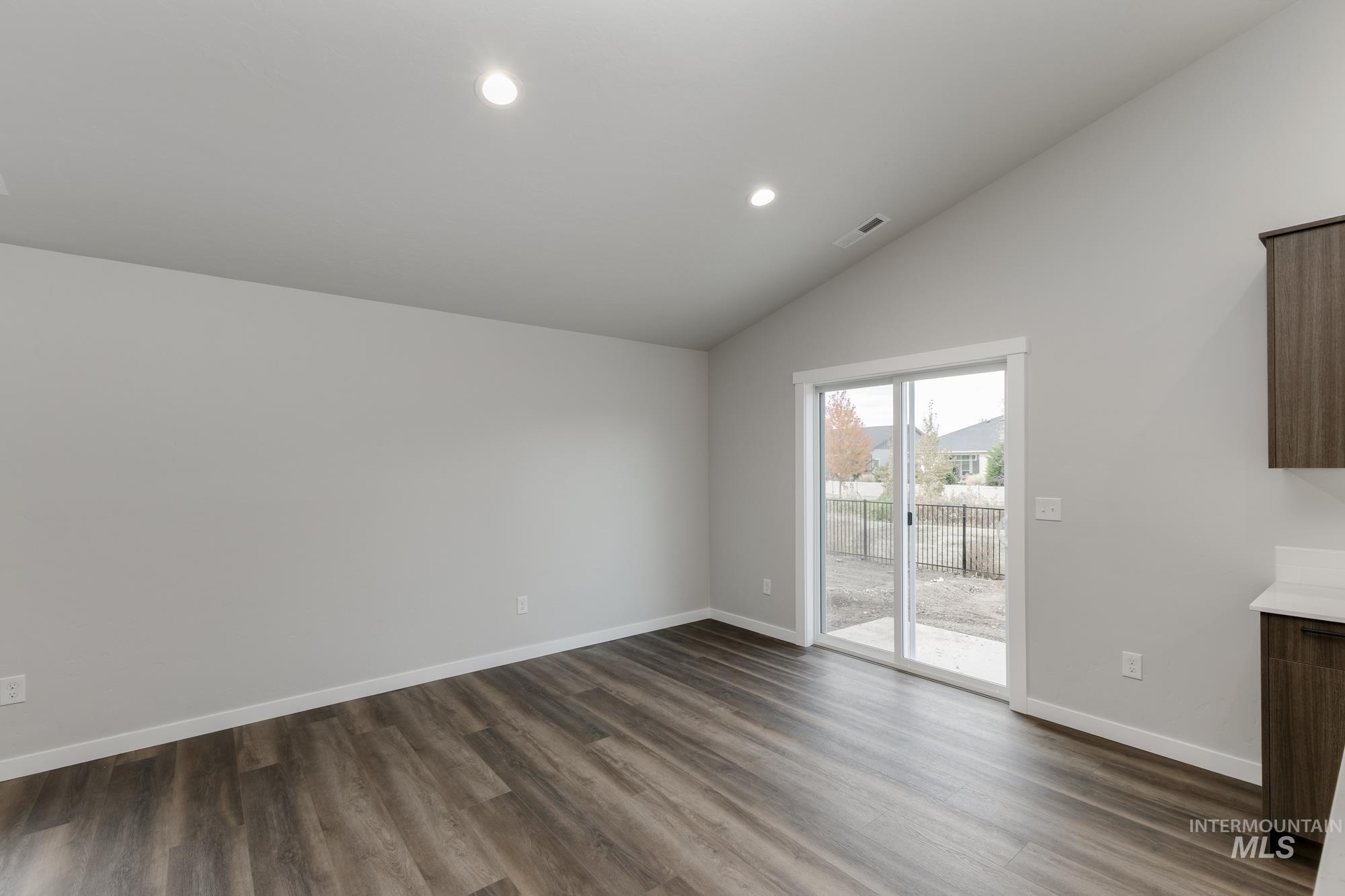 Unfurnished dining area featuring recessed lighting, dark wood-style floors, and lofted ceiling