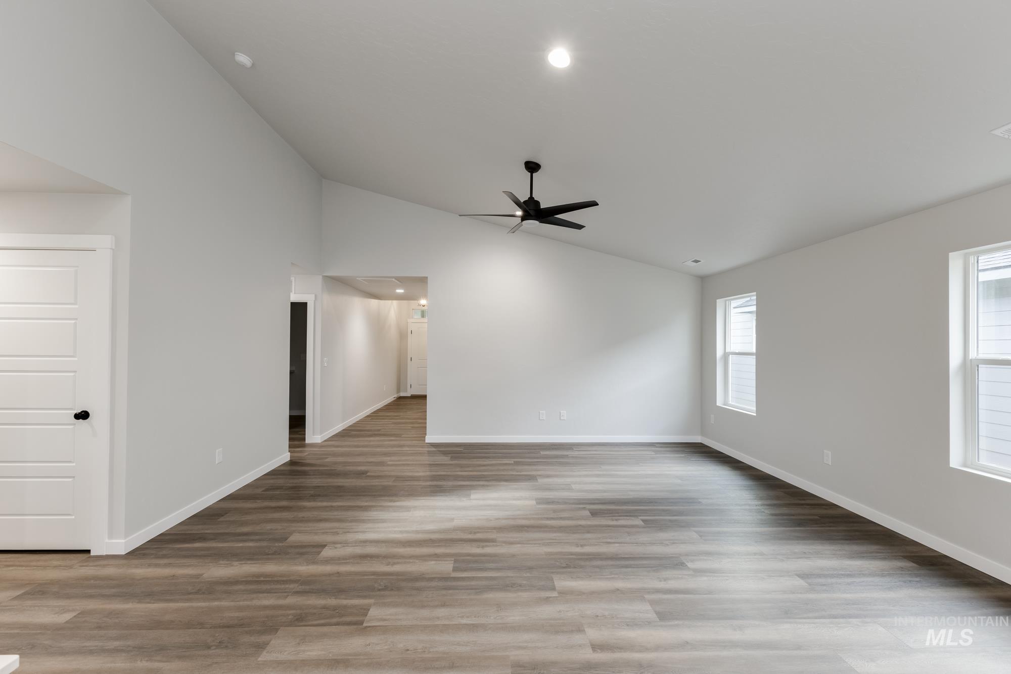 Spare room featuring lofted ceiling, light wood finished floors, a ceiling fan, and recessed lighting