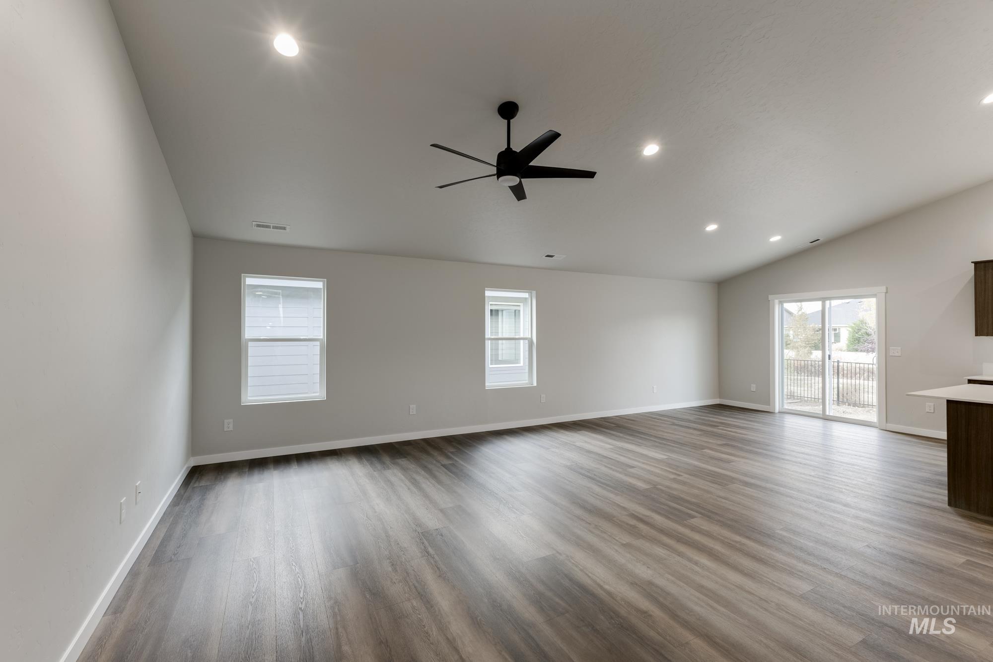 Unfurnished living room featuring recessed lighting, light wood-type flooring, a ceiling fan, and lofted ceiling