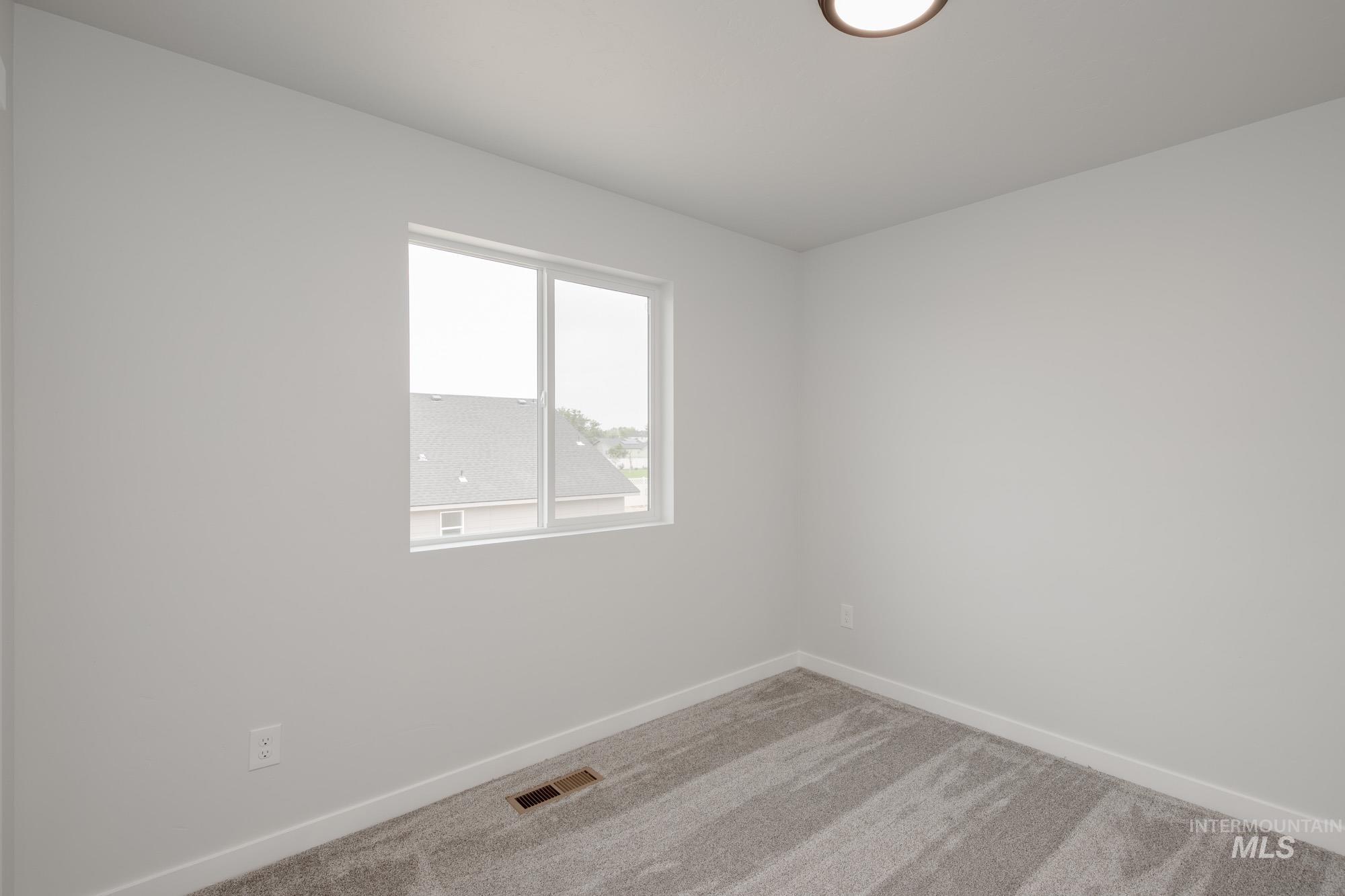 Empty room with carpet and baseboards