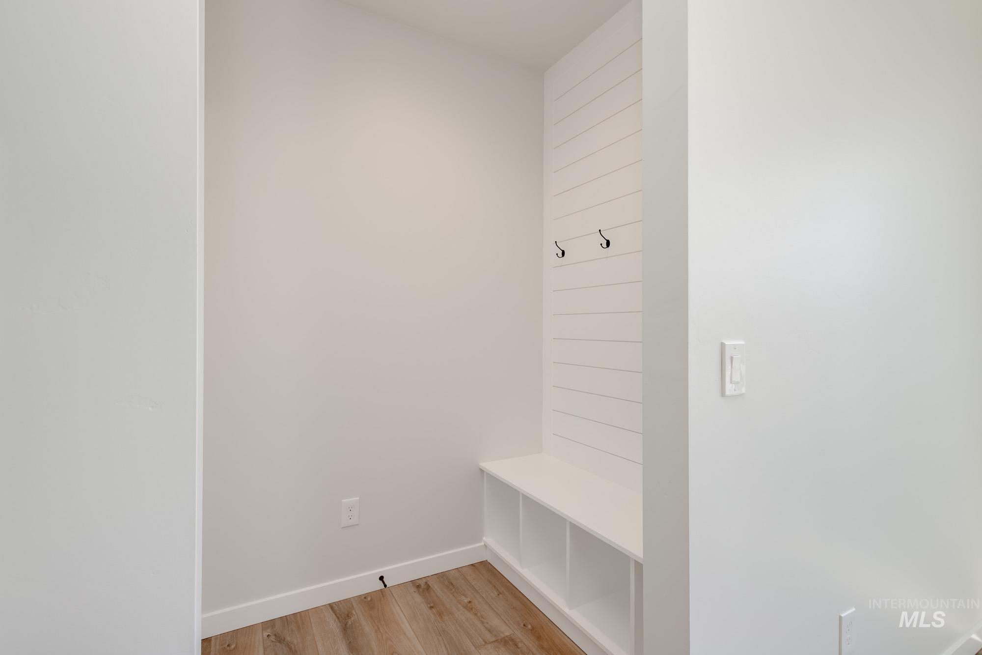 Mudroom featuring light wood-type flooring and baseboards
