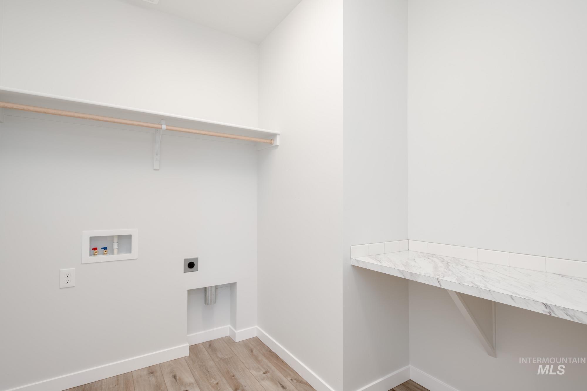 Laundry room featuring light wood finished floors, electric dryer hookup, and hookup for a washing machine