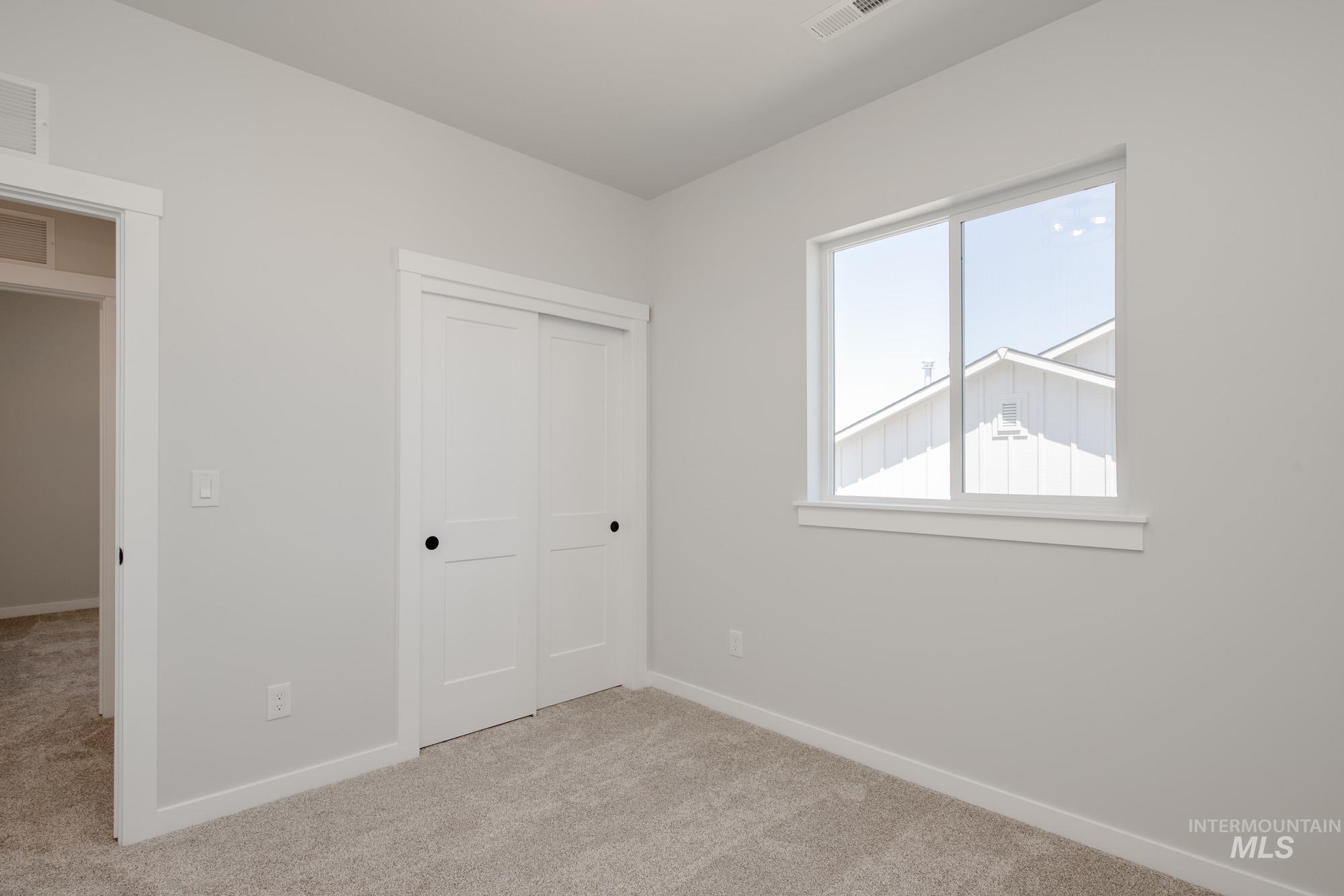 Unfurnished bedroom featuring light carpet and a closet
