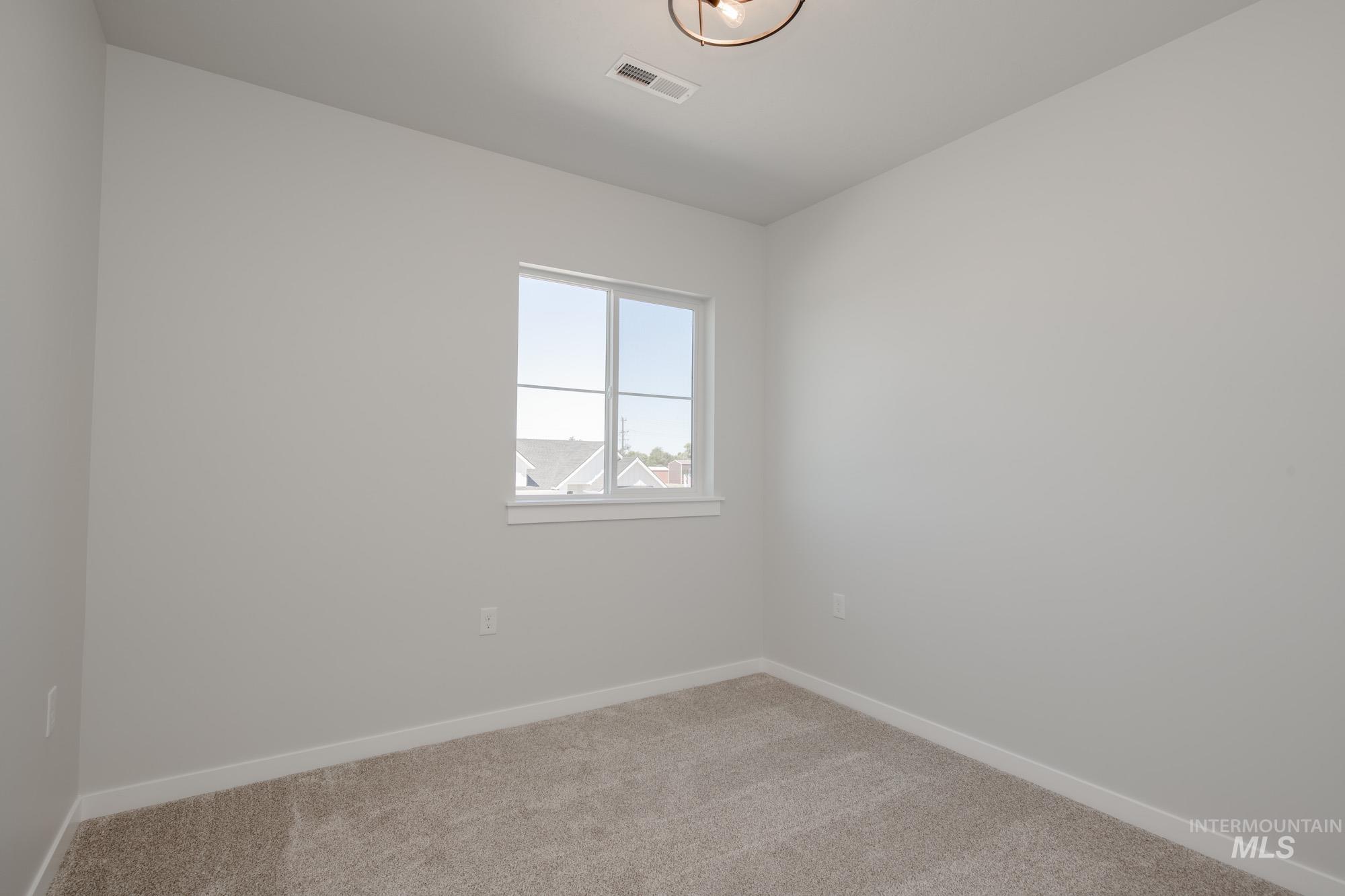 Unfurnished room with light colored carpet and baseboards