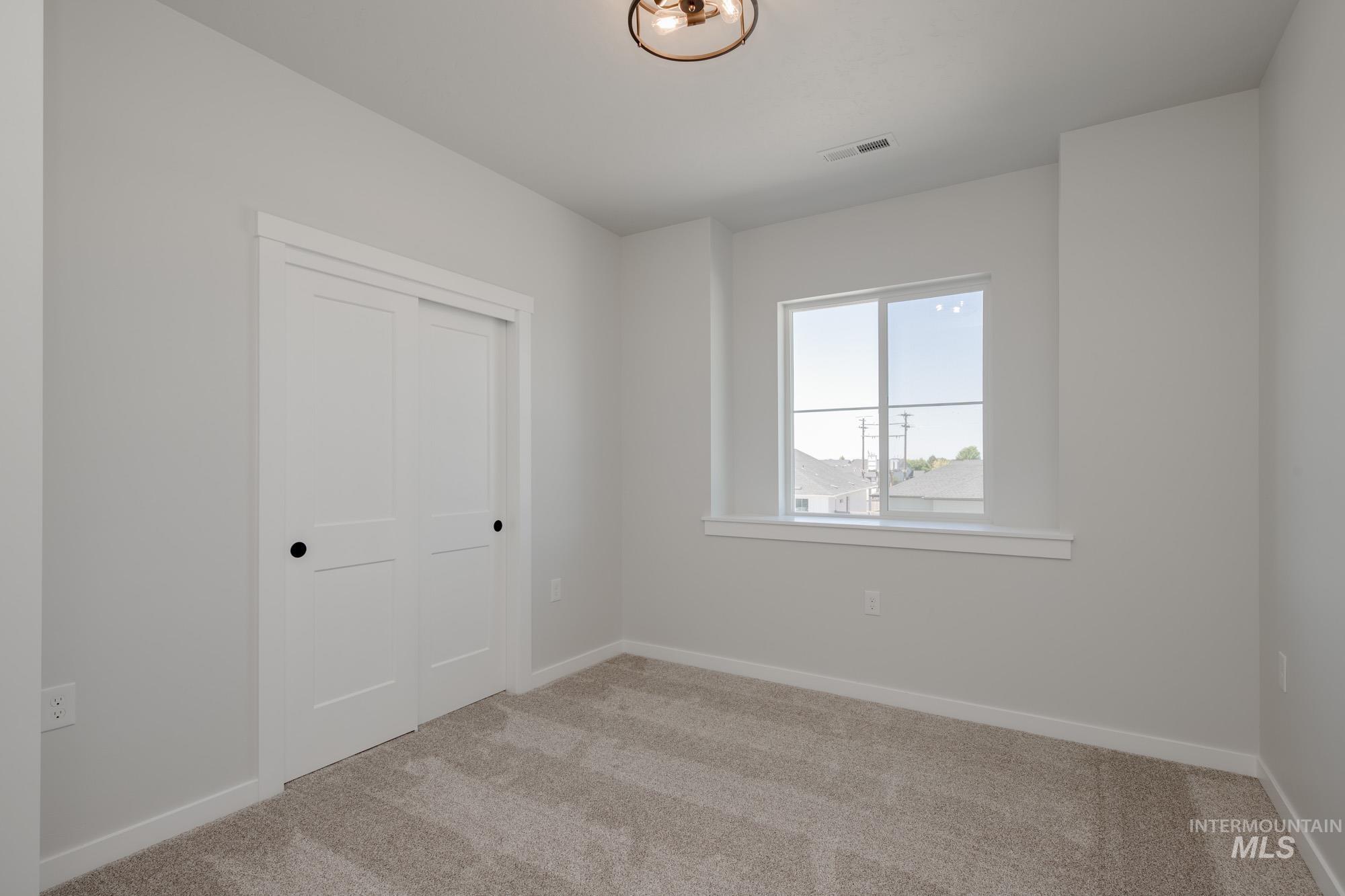 Unfurnished room featuring light colored carpet and baseboards