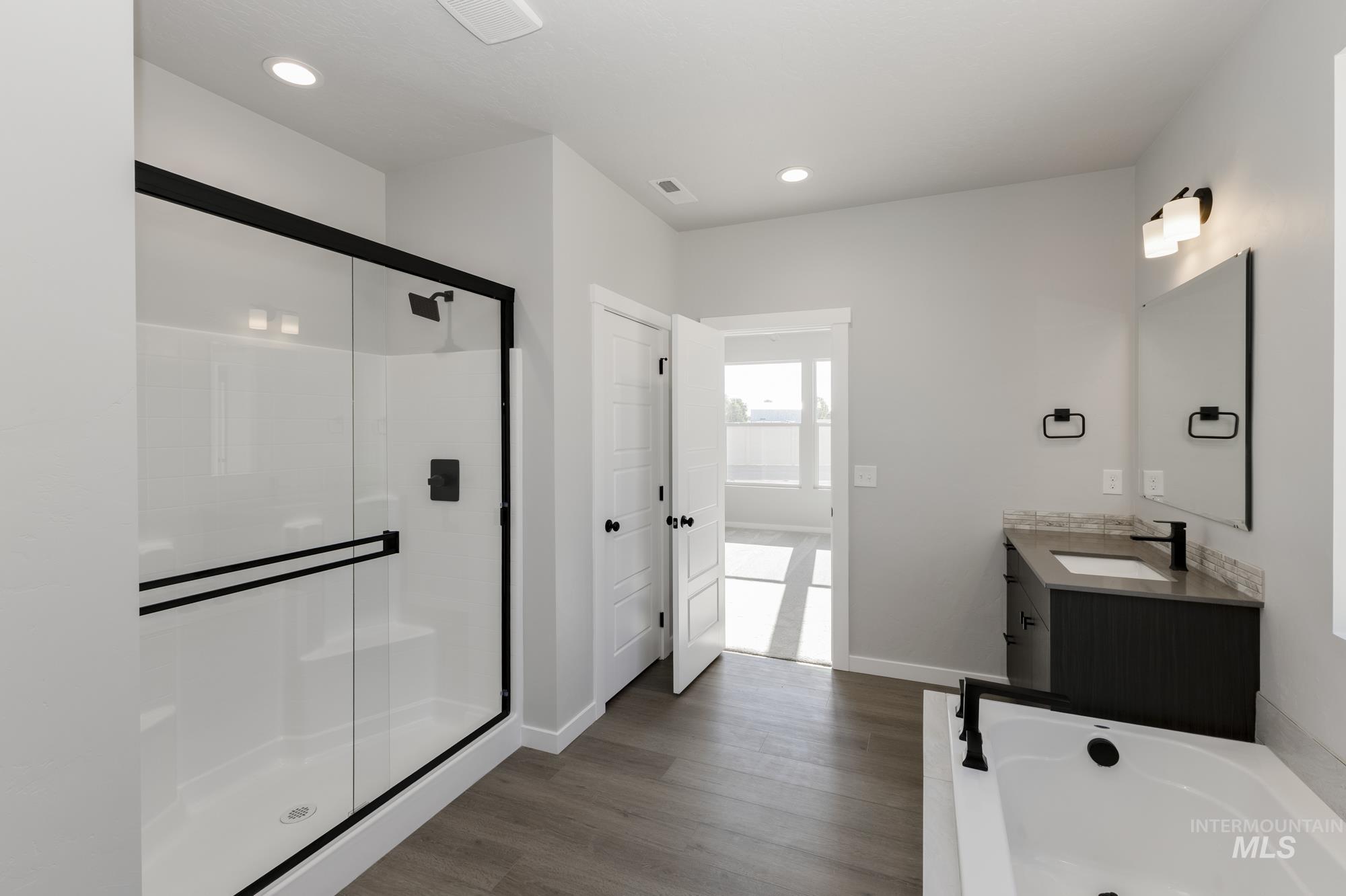 Full bath with vanity, a bath, dark wood-type flooring, a shower stall, and recessed lighting