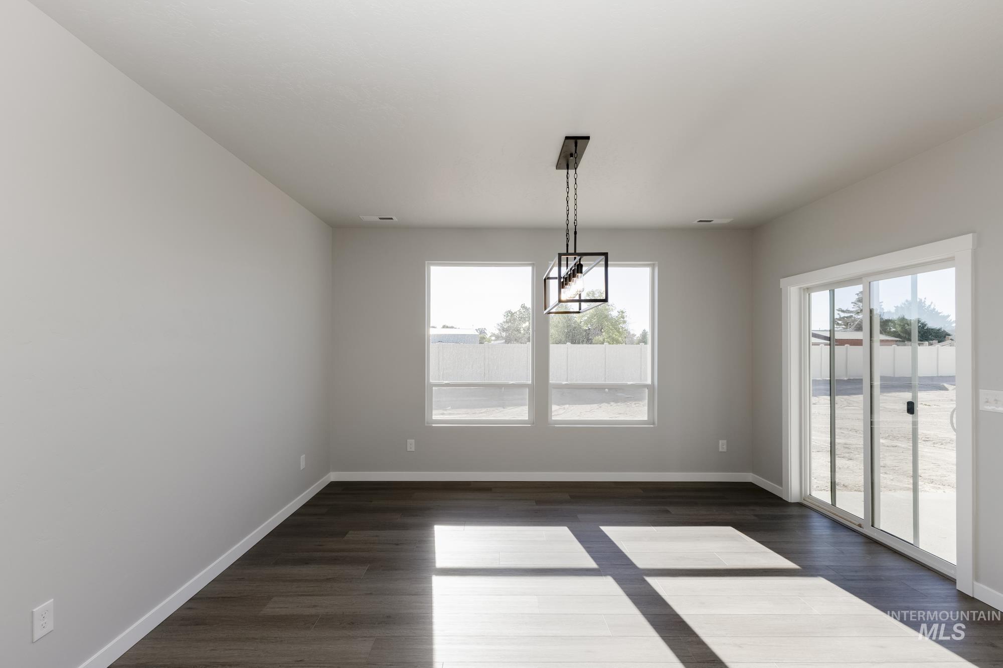 Unfurnished dining area featuring dark wood-style floors
