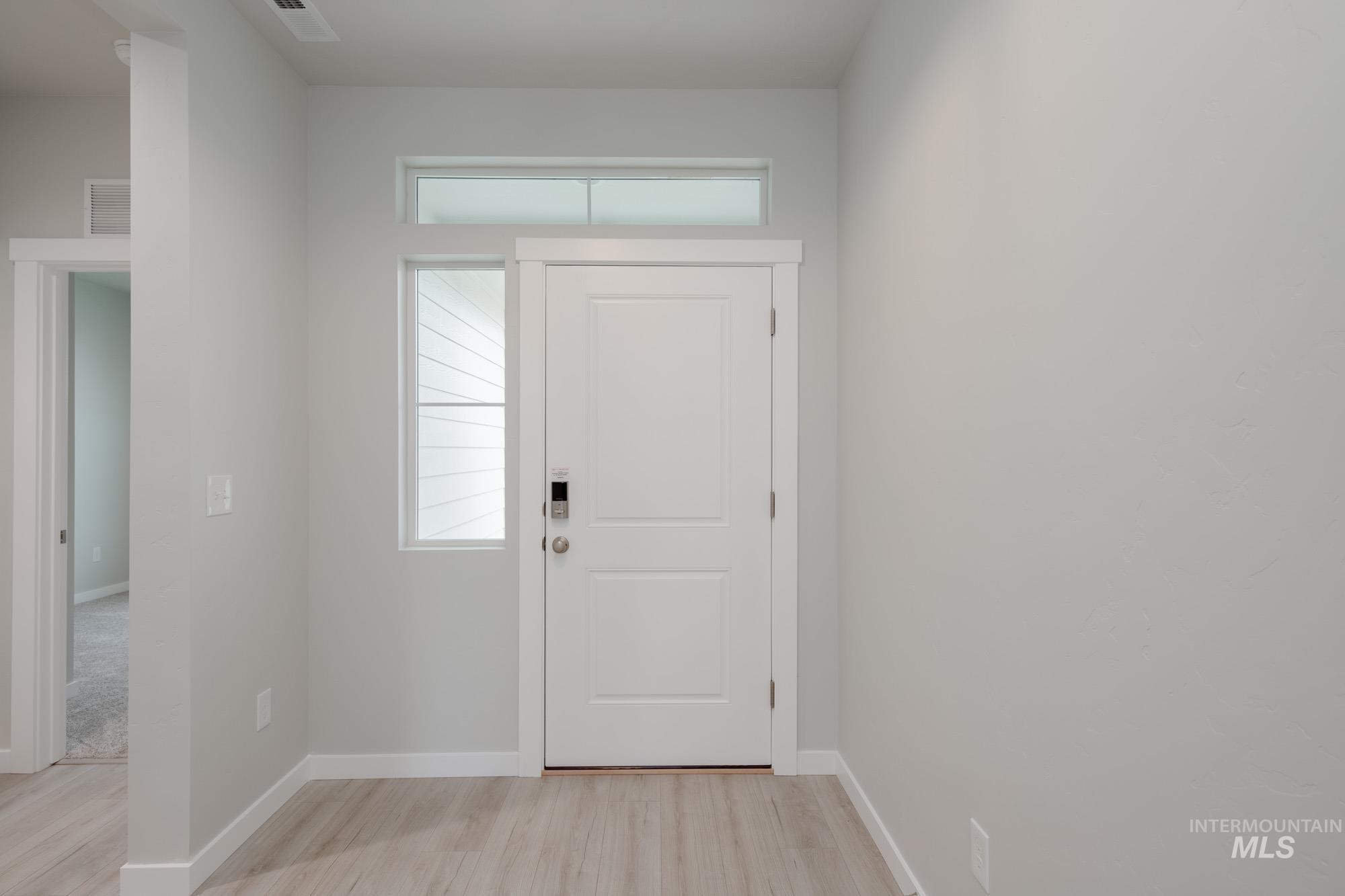 Entrance foyer featuring baseboards and light wood finished floors