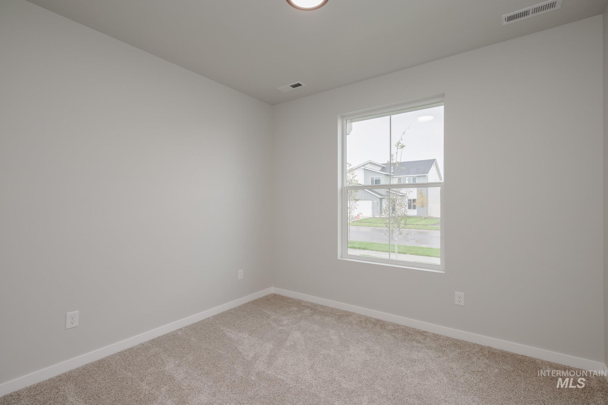 Empty room featuring light colored carpet and baseboards