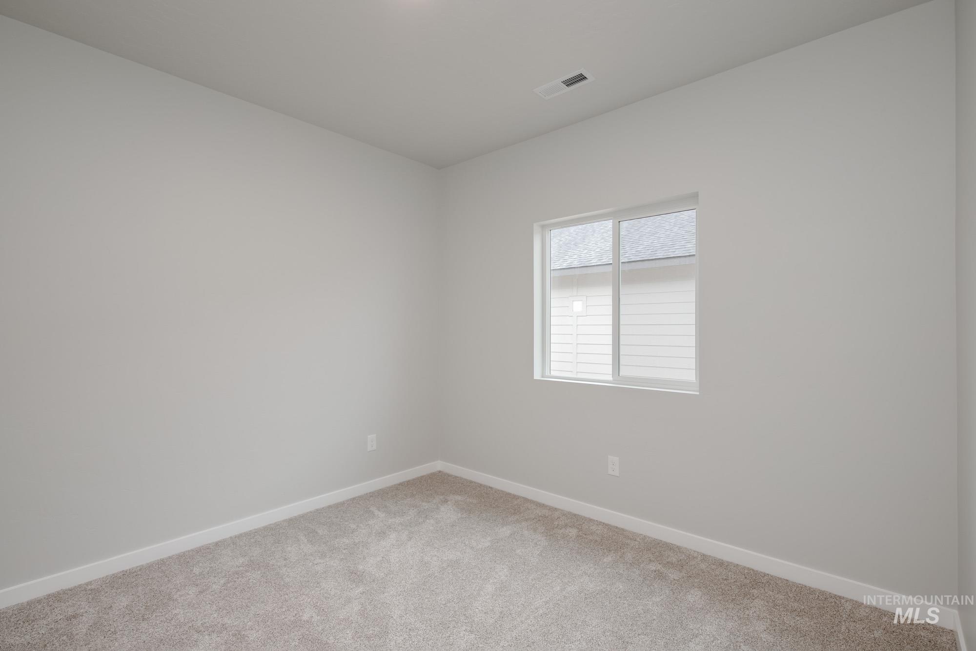 Carpeted empty room with baseboards