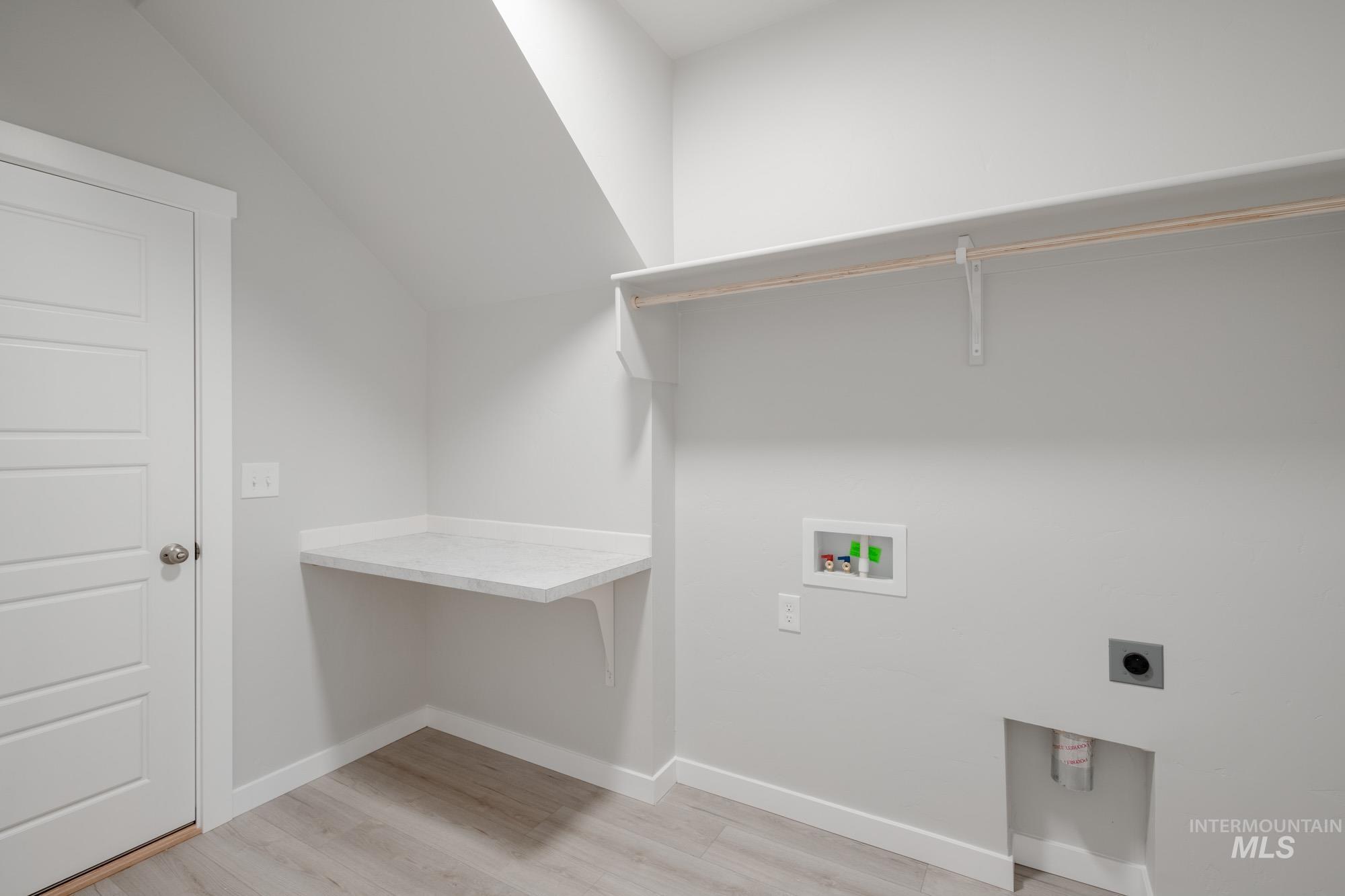 Washroom with light wood-style floors, washer hookup, and hookup for an electric dryer