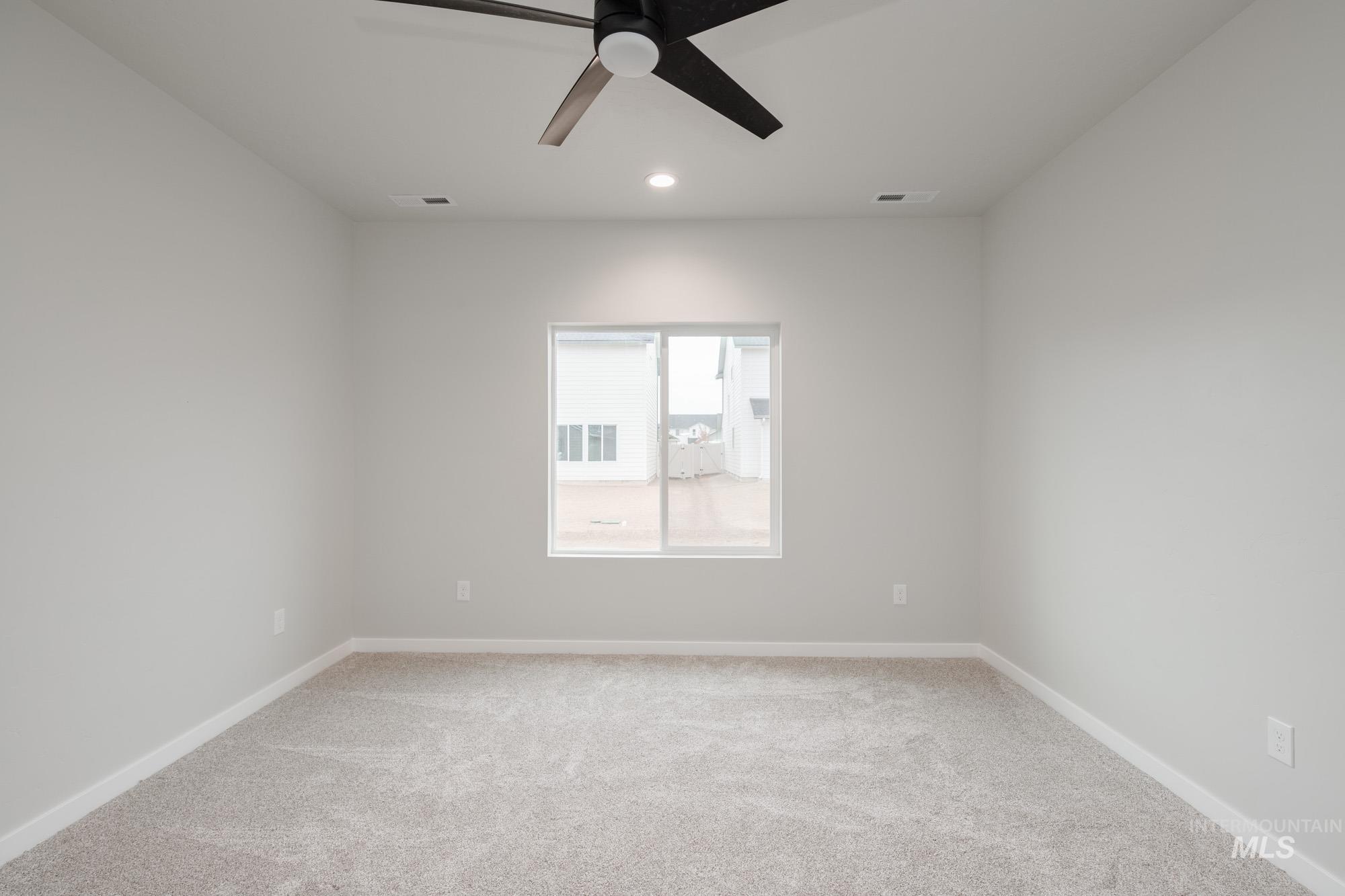 Spare room featuring light colored carpet, a ceiling fan, and recessed lighting