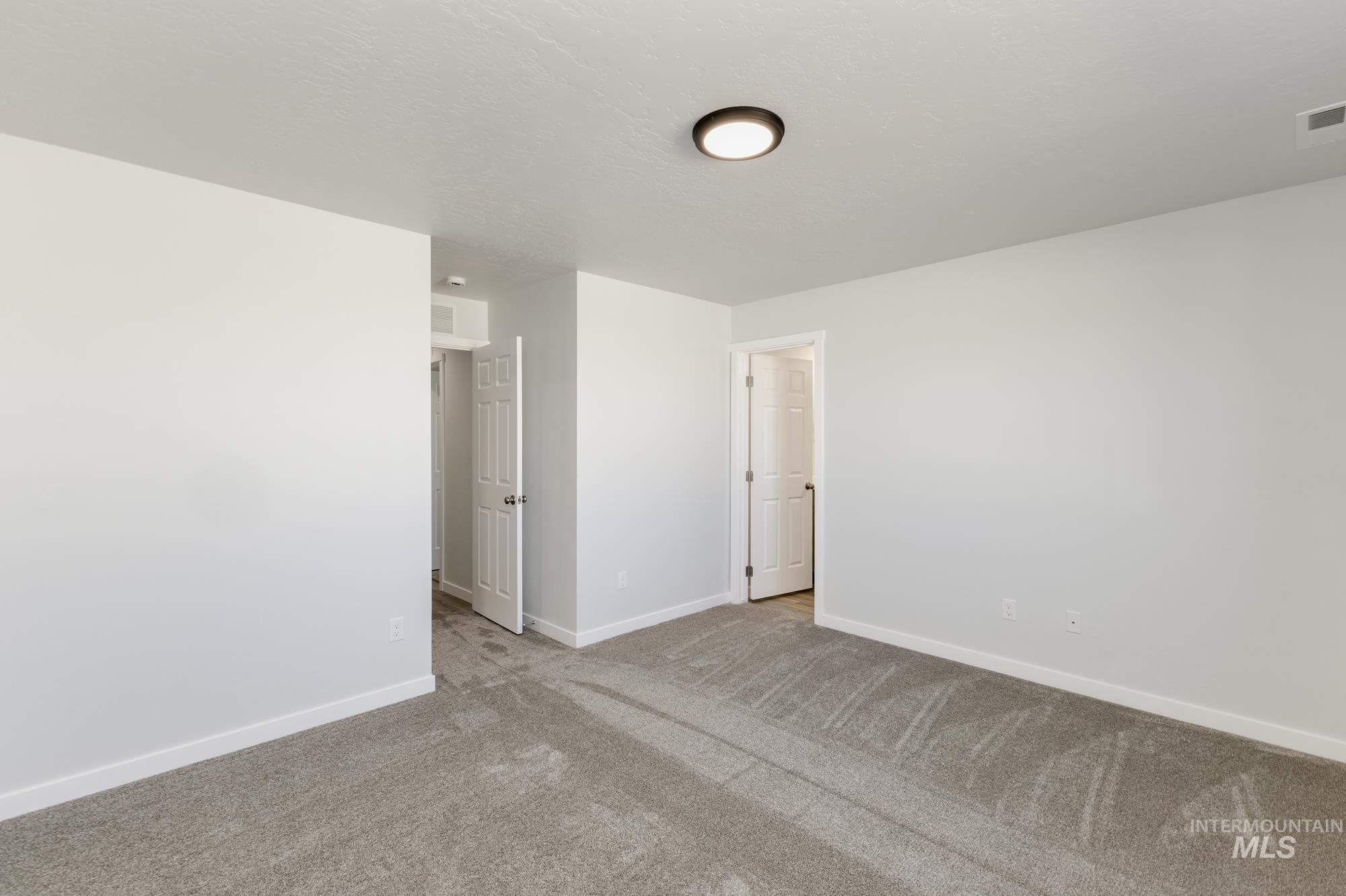 Carpeted spare room with baseboards