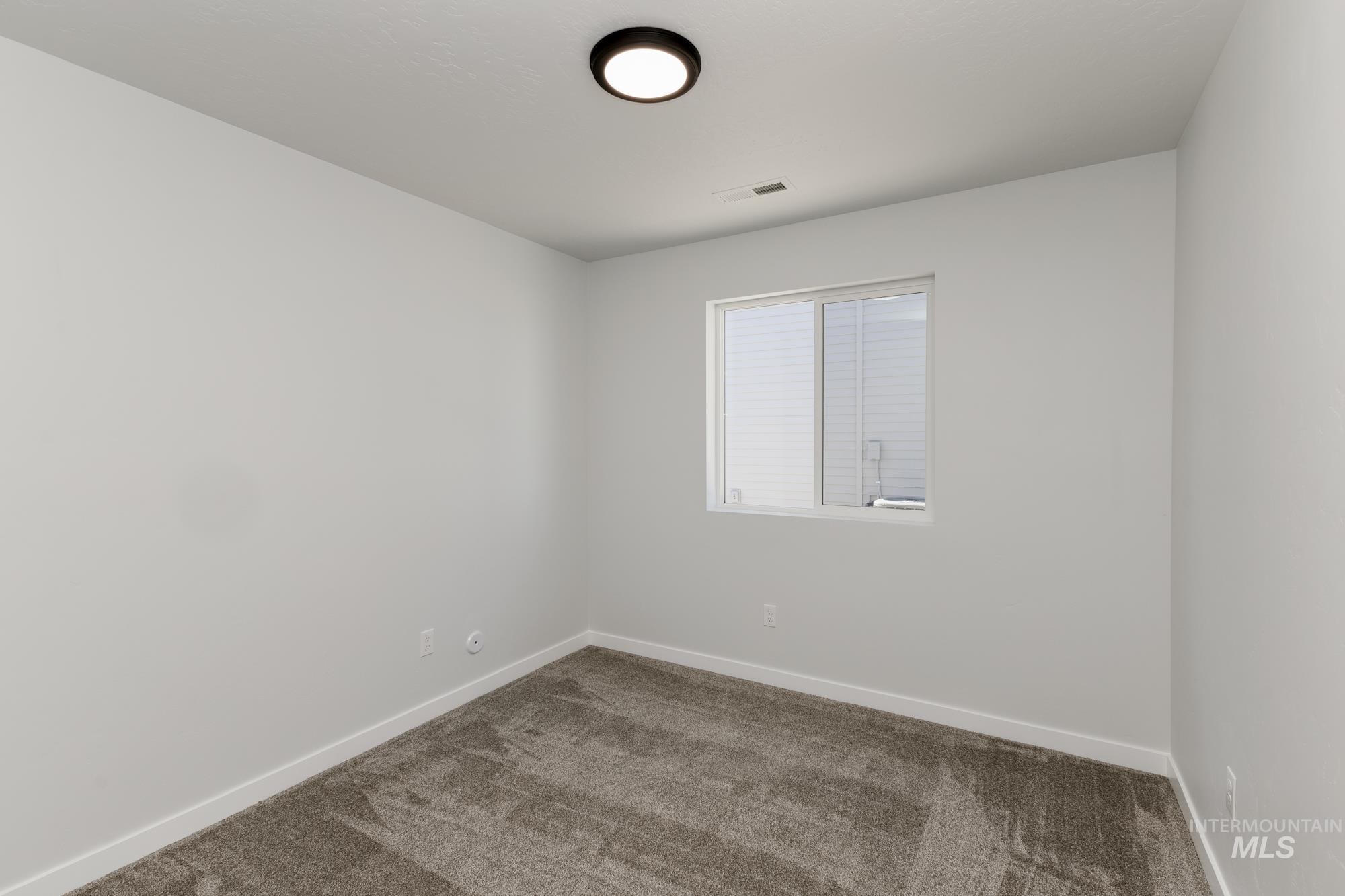 Carpeted empty room featuring baseboards