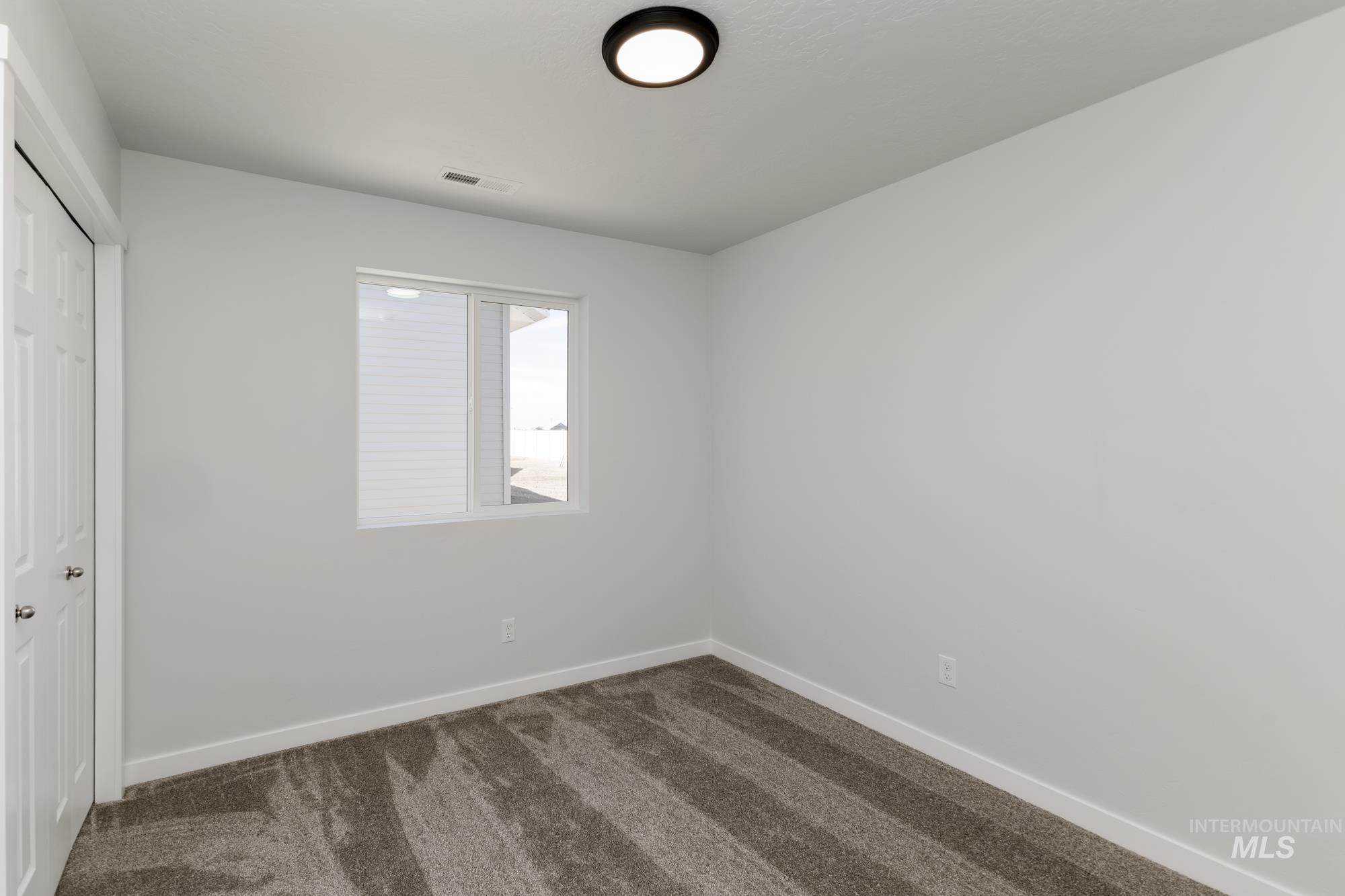 Unfurnished bedroom with dark colored carpet and a closet