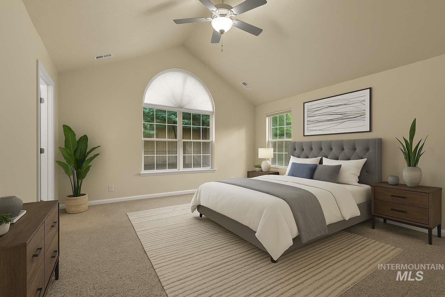 Carpeted bedroom featuring lofted ceiling and a ceiling fan