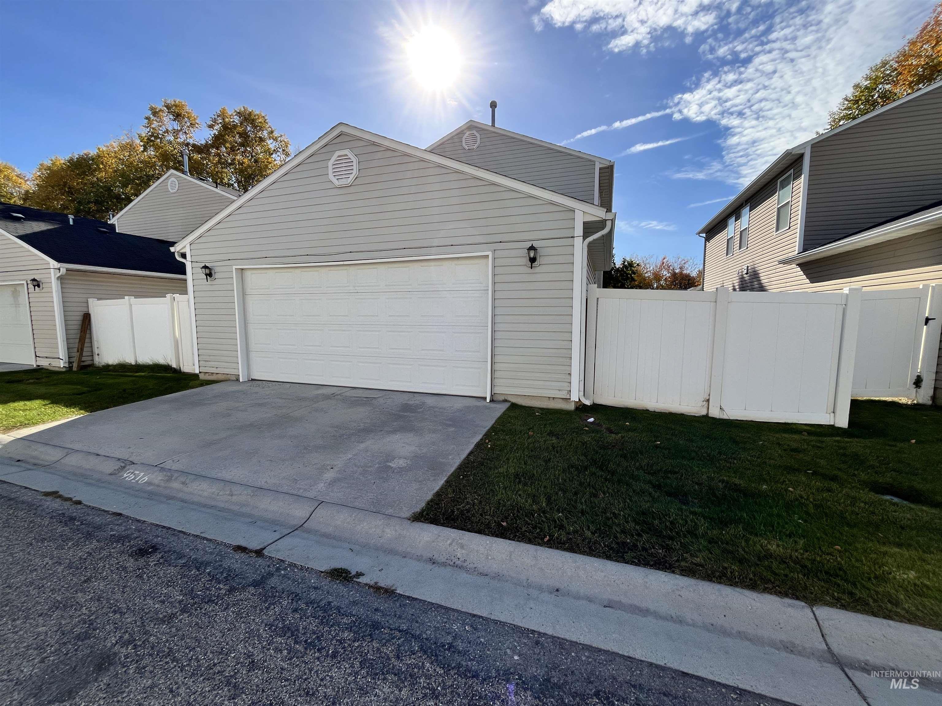 View of front of home with concrete driveway and a garage