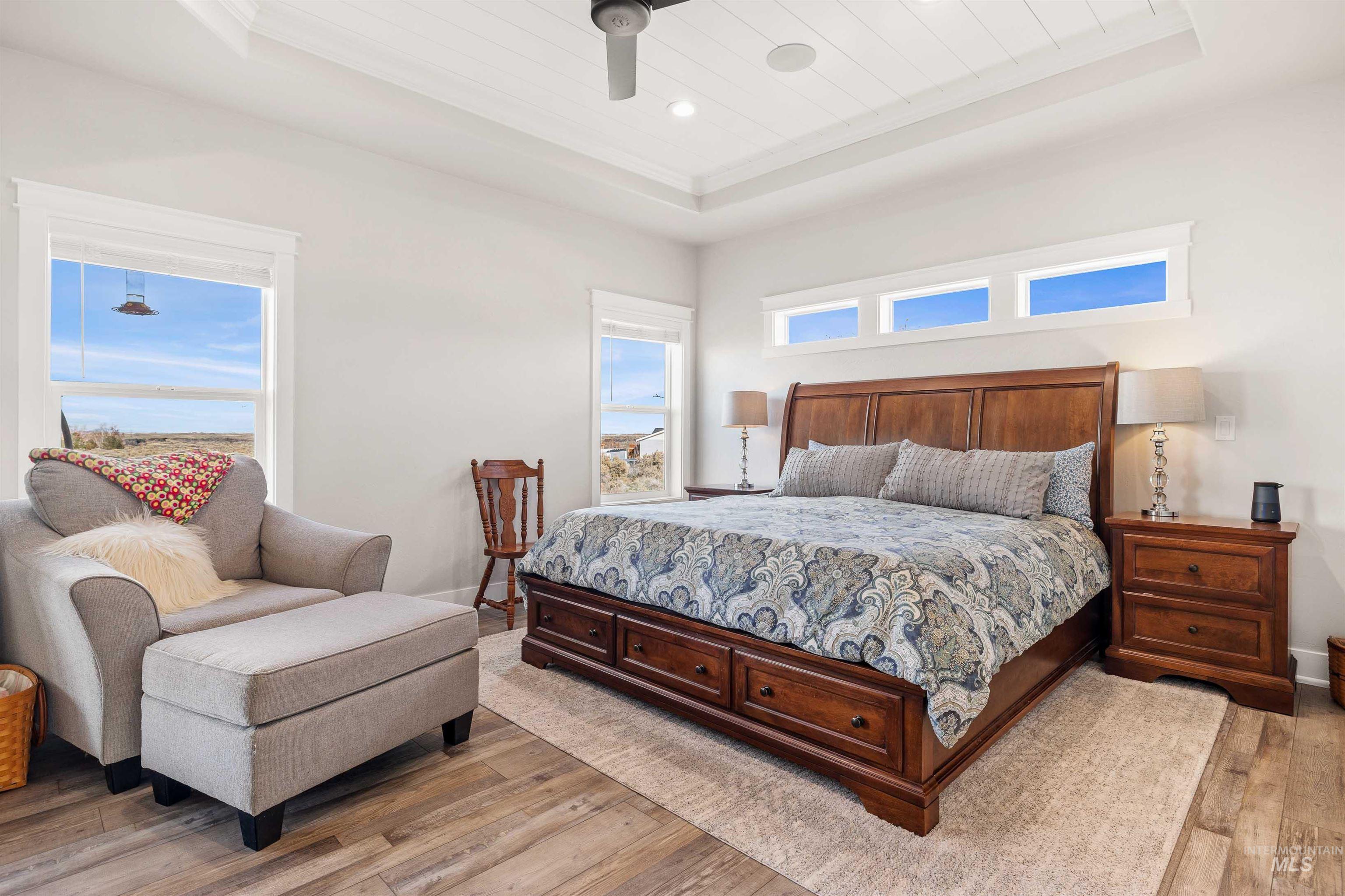 Bedroom featuring a tray ceiling, light wood-type flooring, a ceiling fan, wood ceiling, and recessed lighting