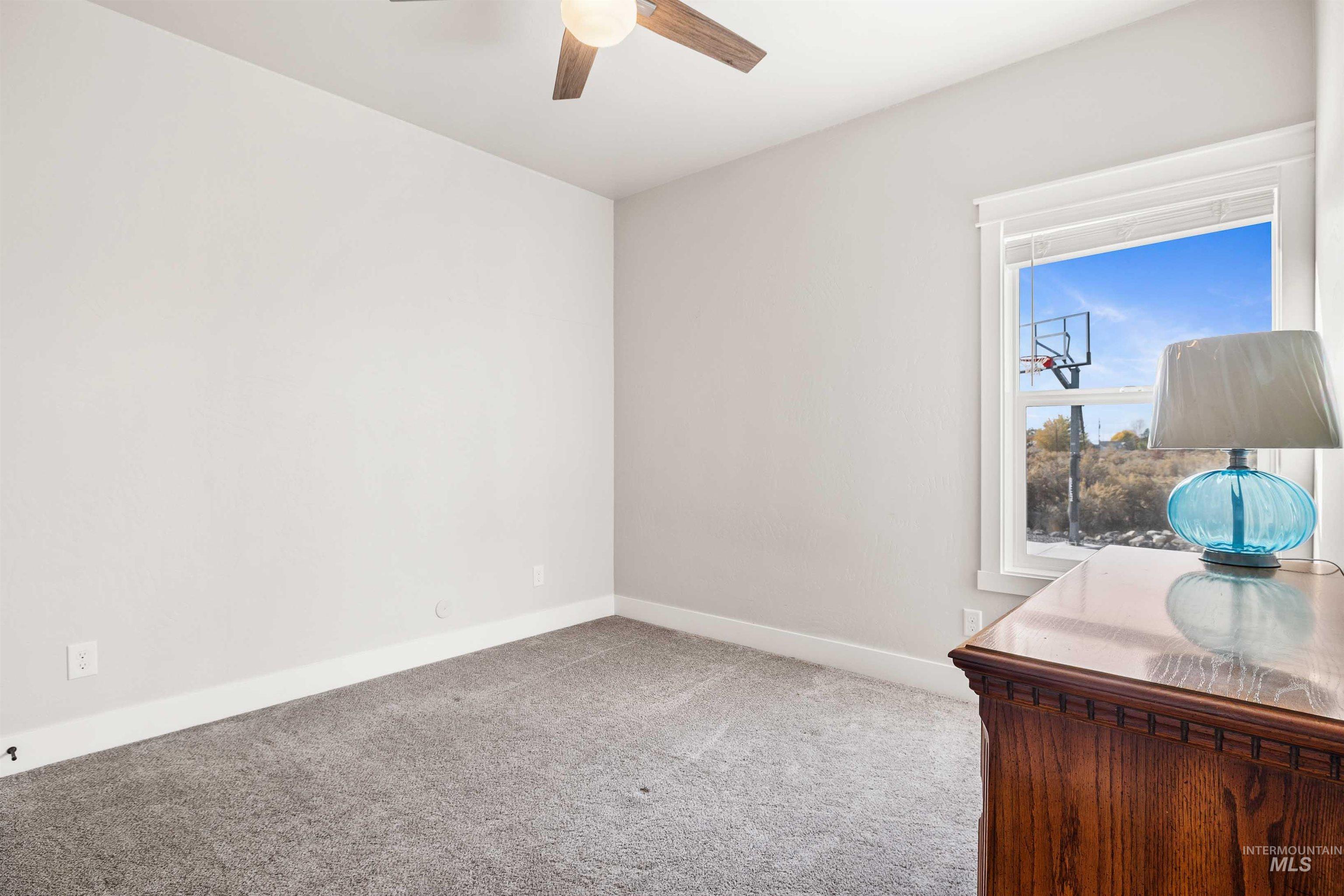 Unfurnished room featuring light carpet and a ceiling fan