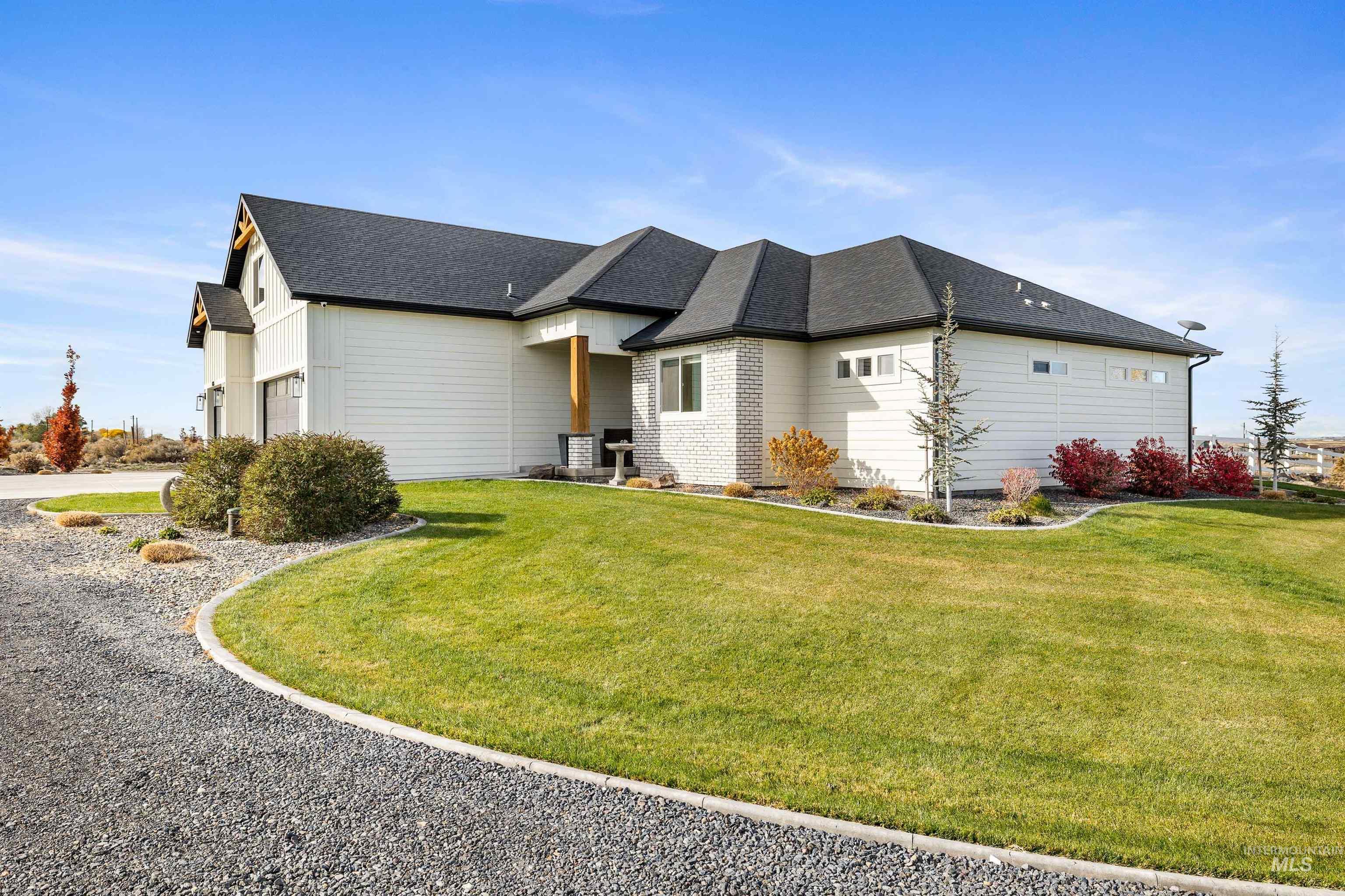 View of home's exterior featuring roof with shingles, a lawn, and a garage