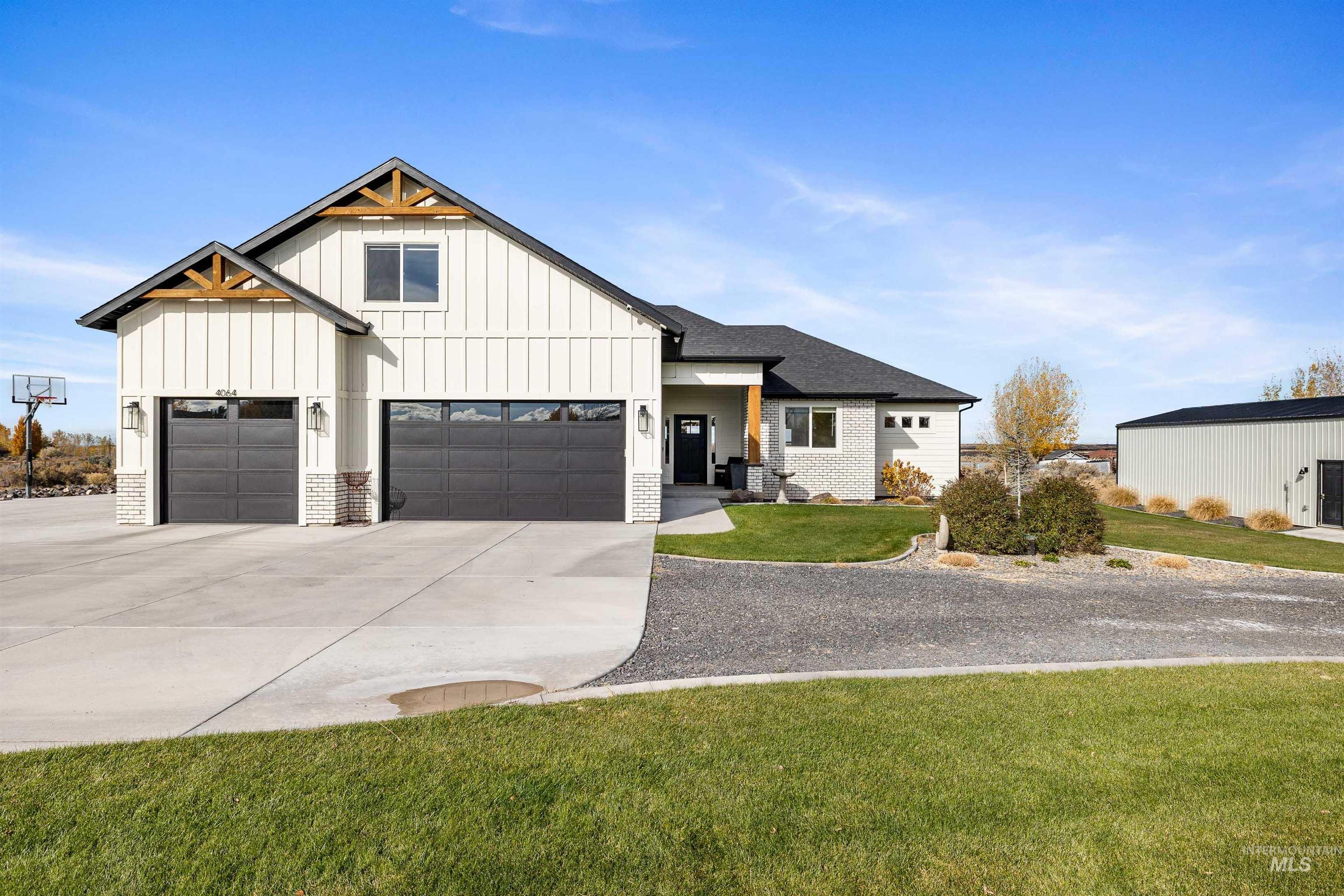 Modern farmhouse featuring a front lawn, board and batten siding, driveway, and a porch