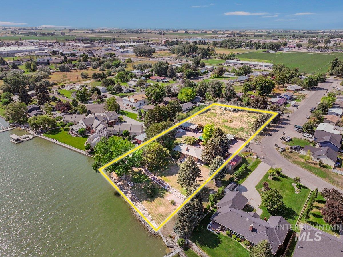 Aerial perspective of suburban area with property boundaries highlighted and a large body of water