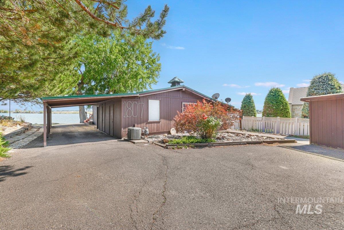 View of front of house with an attached carport and asphalt driveway