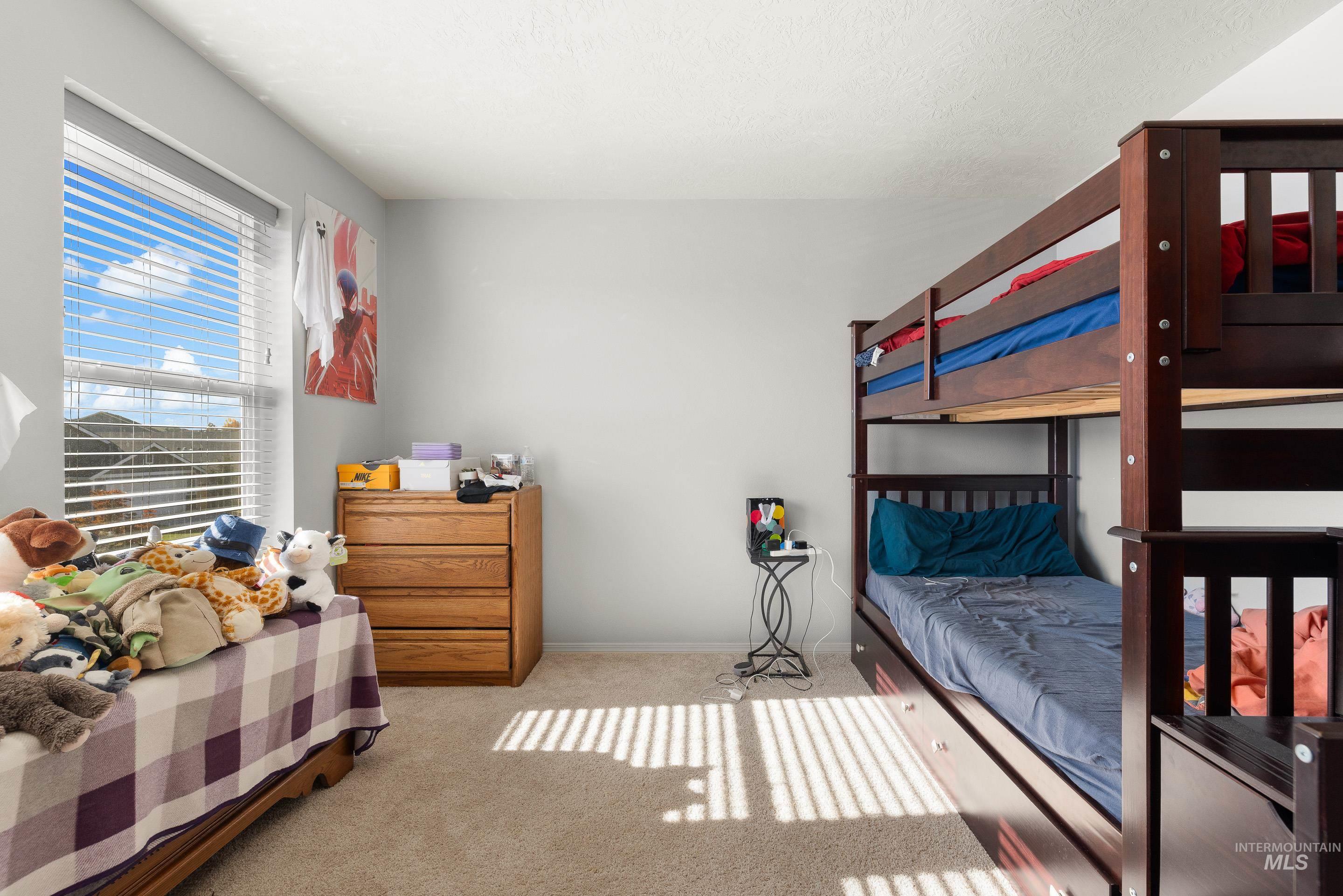 Bedroom featuring light carpet and baseboards